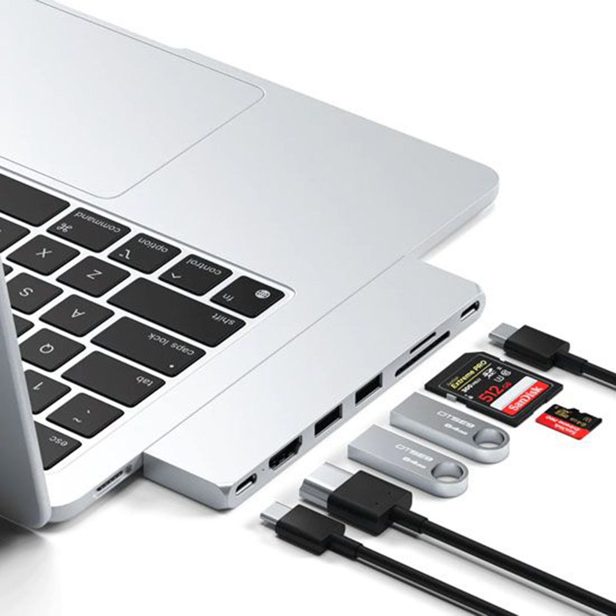 Ordenador portátil con múltiples adaptadores USB y tarjetas SD enchufados, más unidades USB.