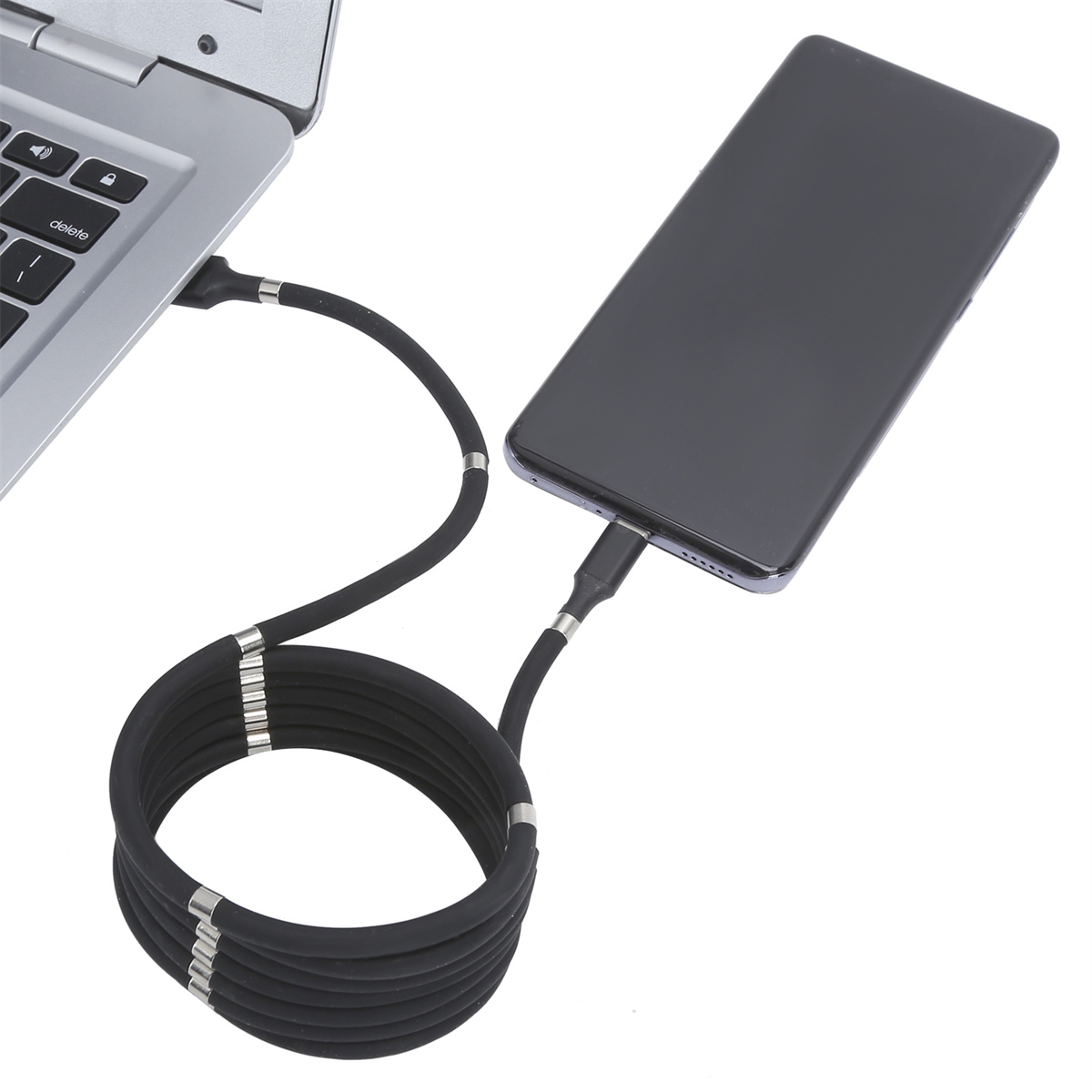 Schwarzes Ladekabel um Laptop und Telefon gewickelt, verbunden, auf weißem Hintergrund.