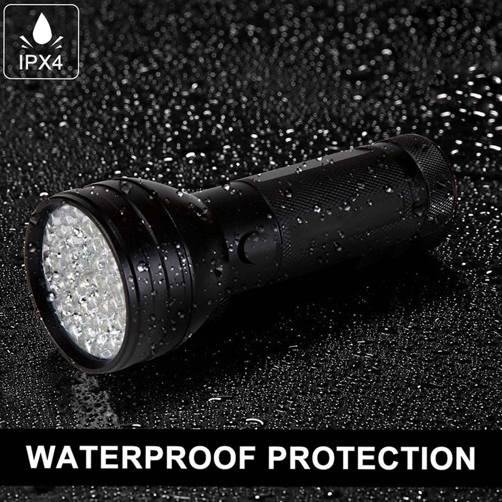 Schwarze wasserdichte Taschenlampe mit Wassertropfen. Das Licht ist an. Schwarzer Hintergrund.