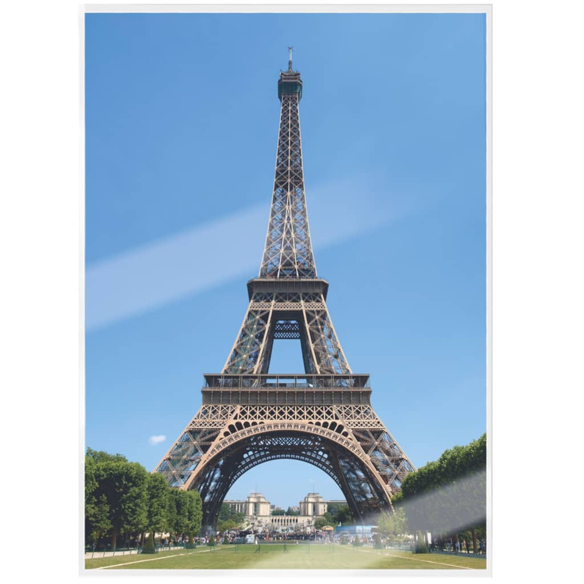 Der Eiffelturm in Paris, Frankreich. Blauer Himmel im Hintergrund, Bäume im Vordergrund auf beiden Seiten.