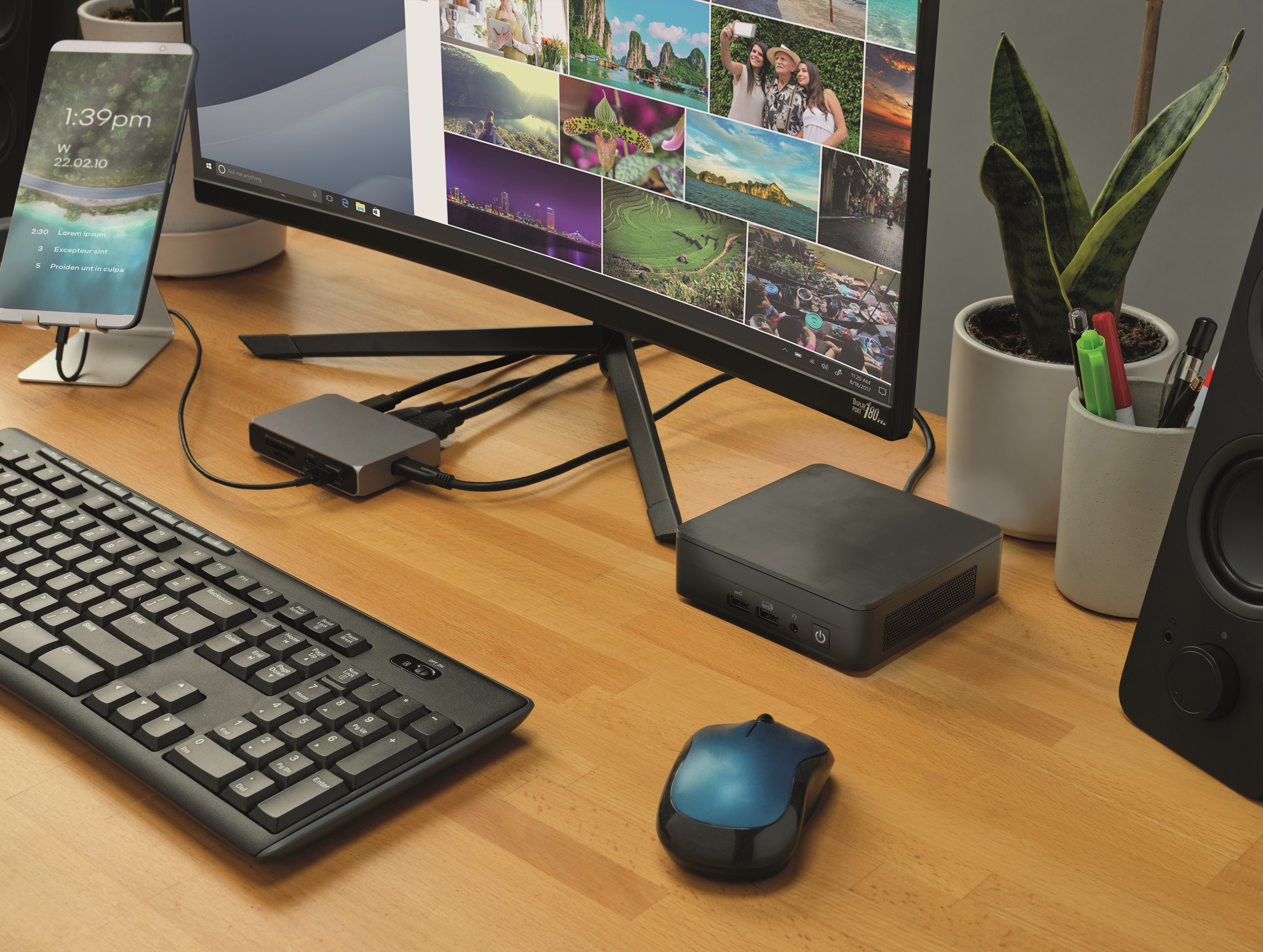 Biurko z monitorem, klawiaturą, myszą i hubem podłączonym do laptopa.