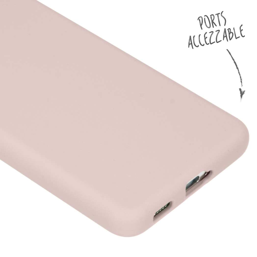 Gros plan d'une coque de téléphone rose clair avec ports accessibles indiqués par une flèche.