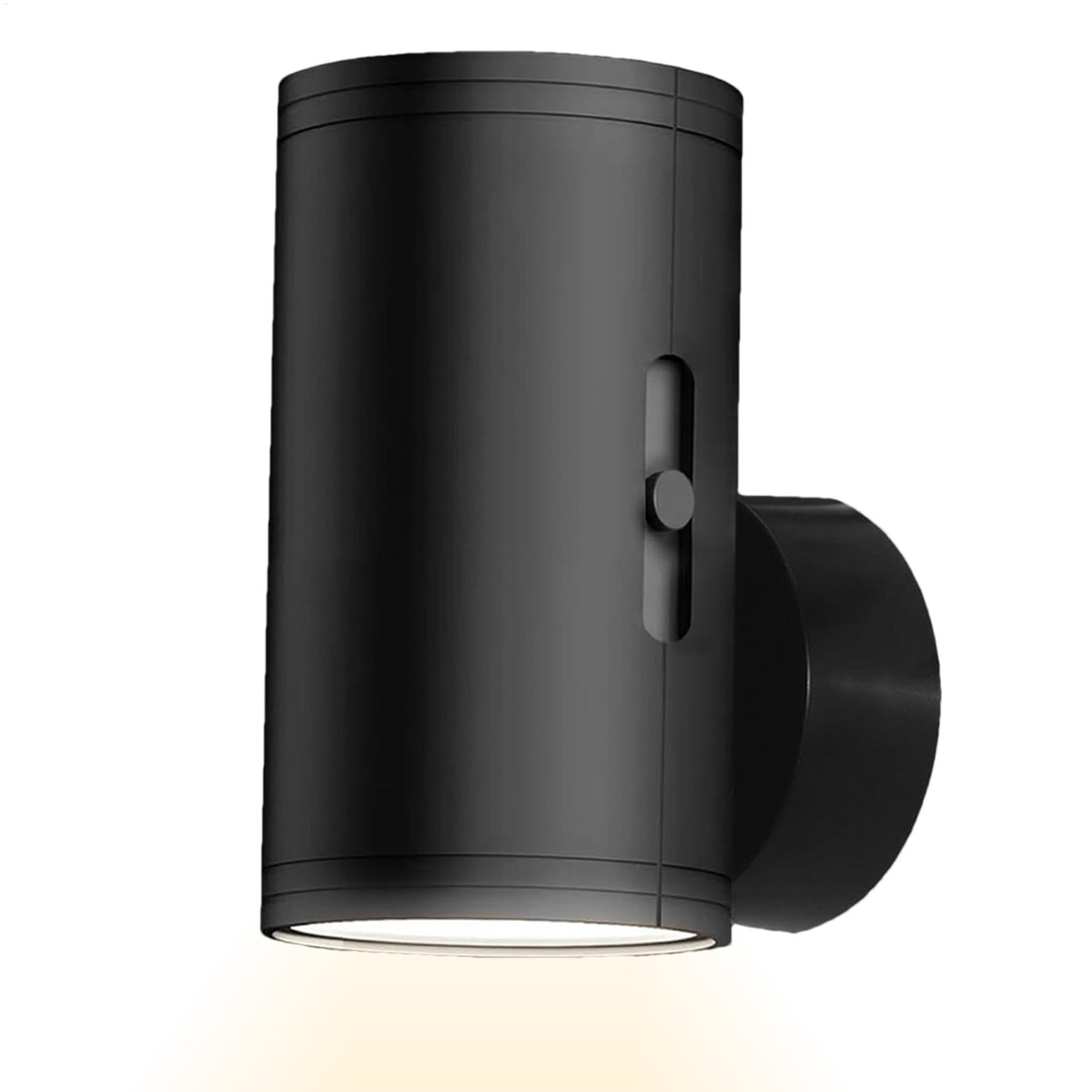 Eine schwarze Außenwandleuchte, zylindrische Form, mit einem Schalter. Das Licht ist an.