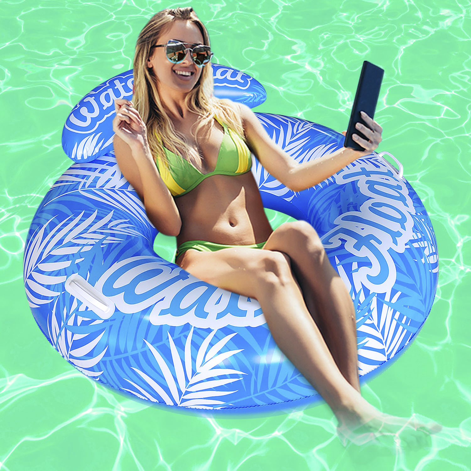 Una donna con occhiali da sole e bikini galleggia in piscina su un anello gonfiabile blu e bianco.