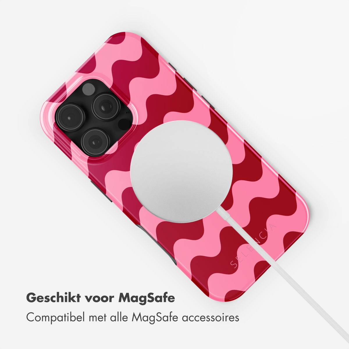 Une coque d'iPhone avec un motif ondulé rose et rouge. La coque est connectée à un chargeur.