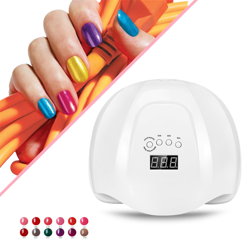 Eine Hand zeigt farbigen Nagellack neben einem Nageltrockner. Der Trockner ist weiß mit Digitalanzeige.