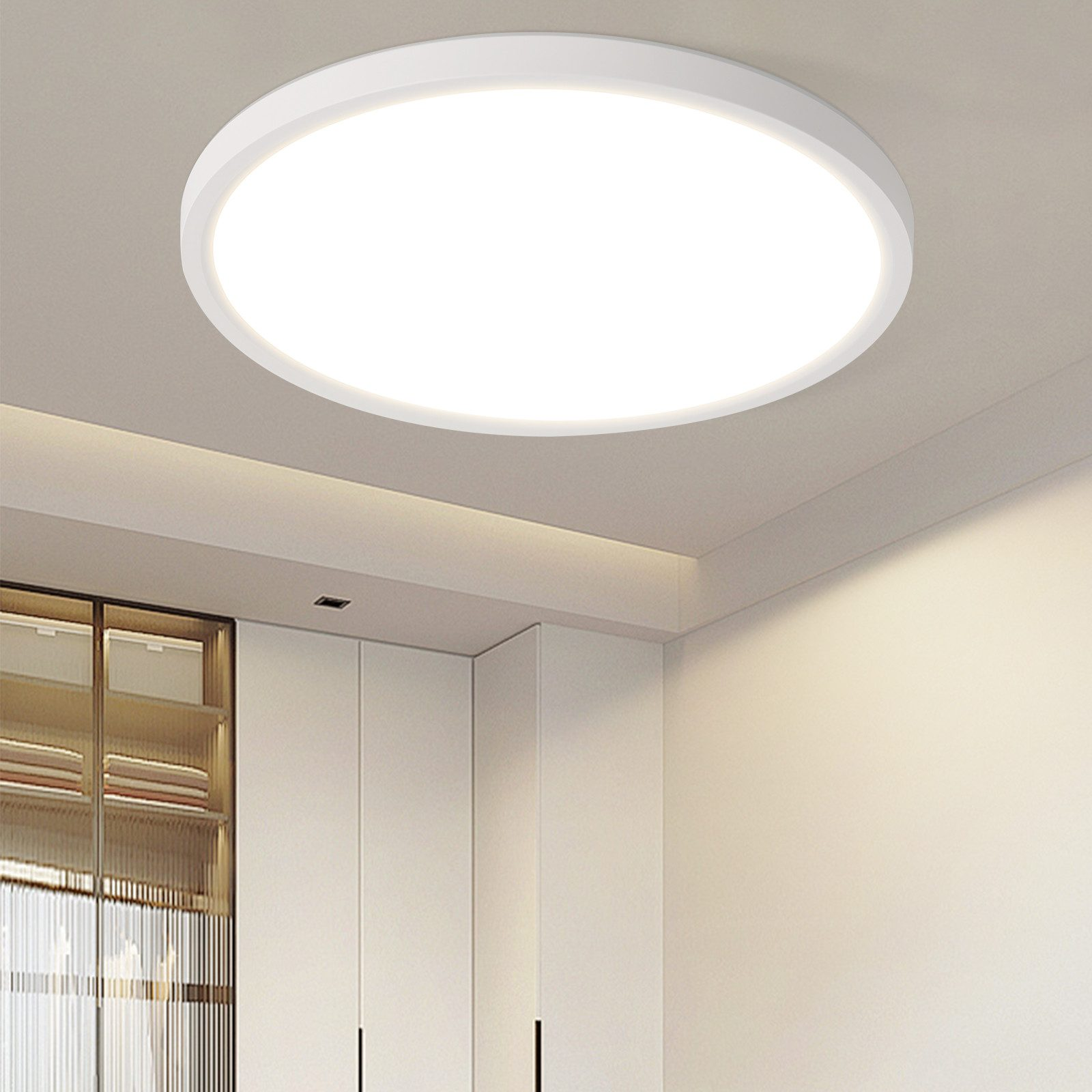 Plafoniera circolare bianca, centrata in una stanza bianca con una luce brillante e uniforme.