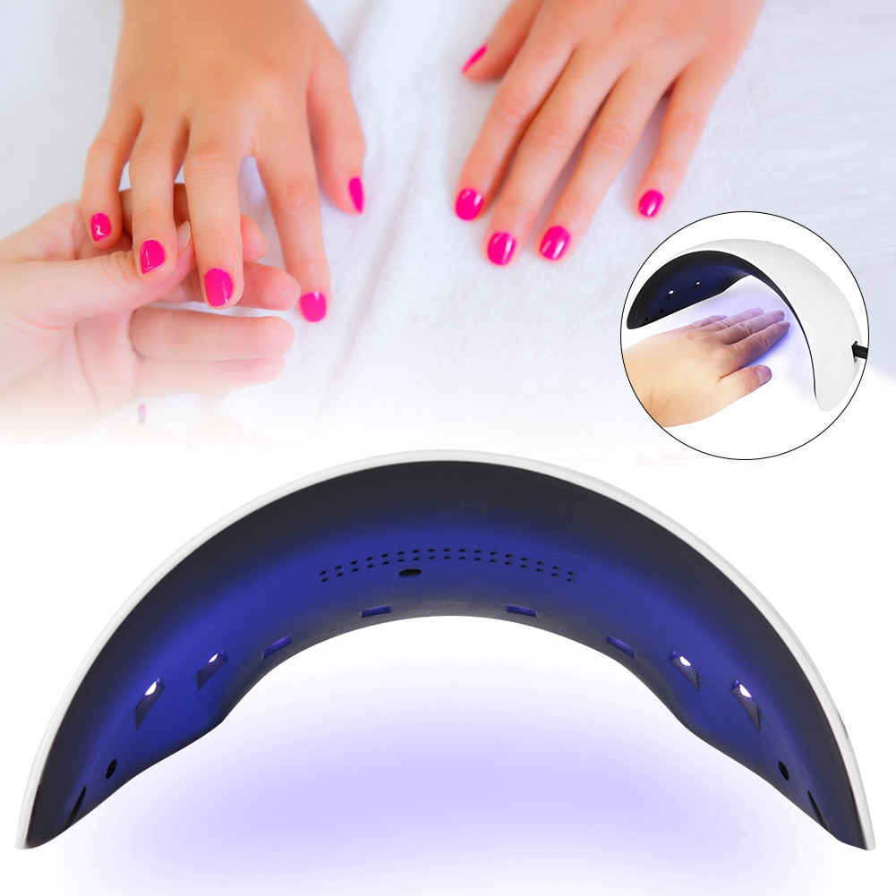 Zwei Hände mit pinkfarbenem Nagellack unter einer UV-Nagellampe.