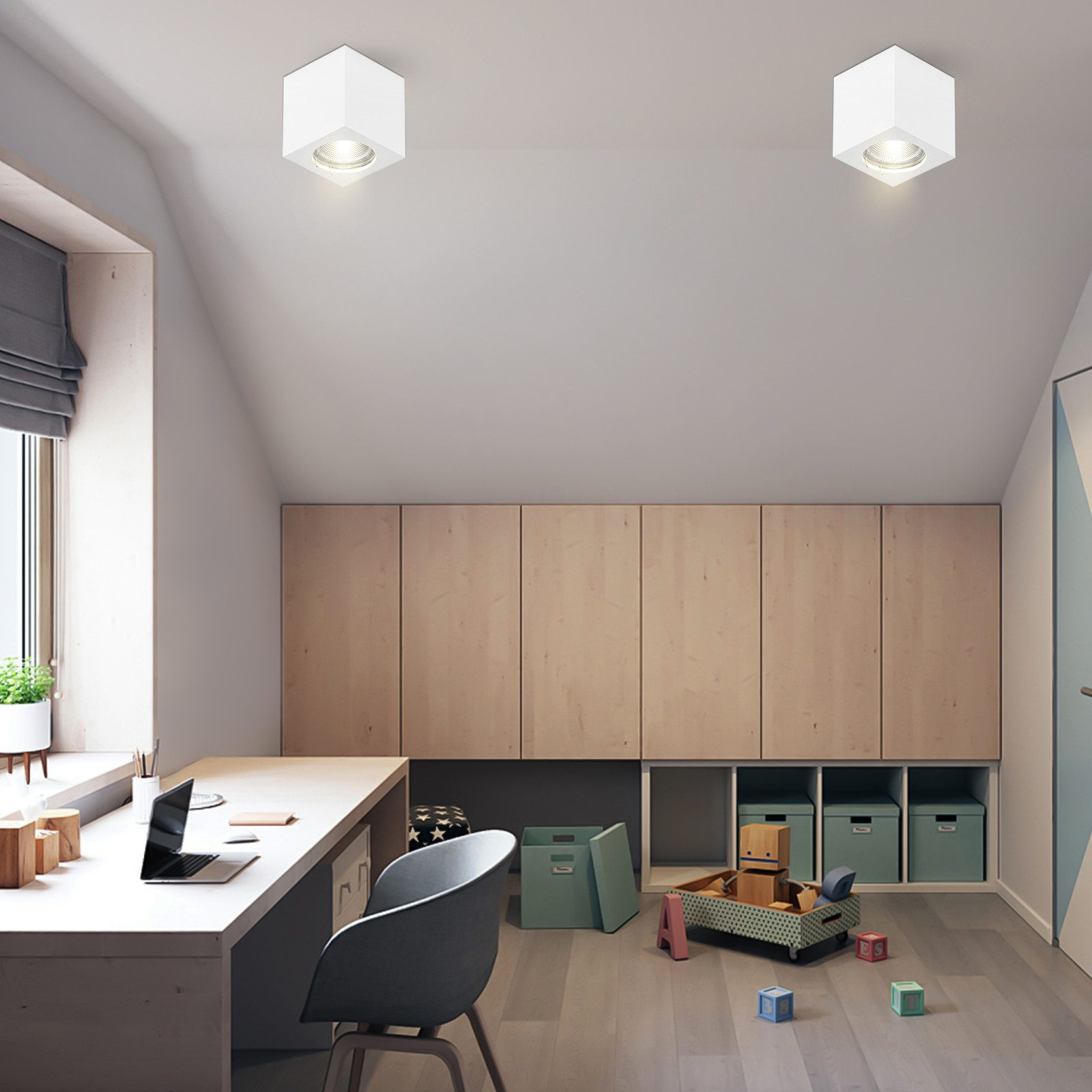 Una stanza ben illuminata con una scrivania e un laptop. Due luci quadrate sul soffitto.