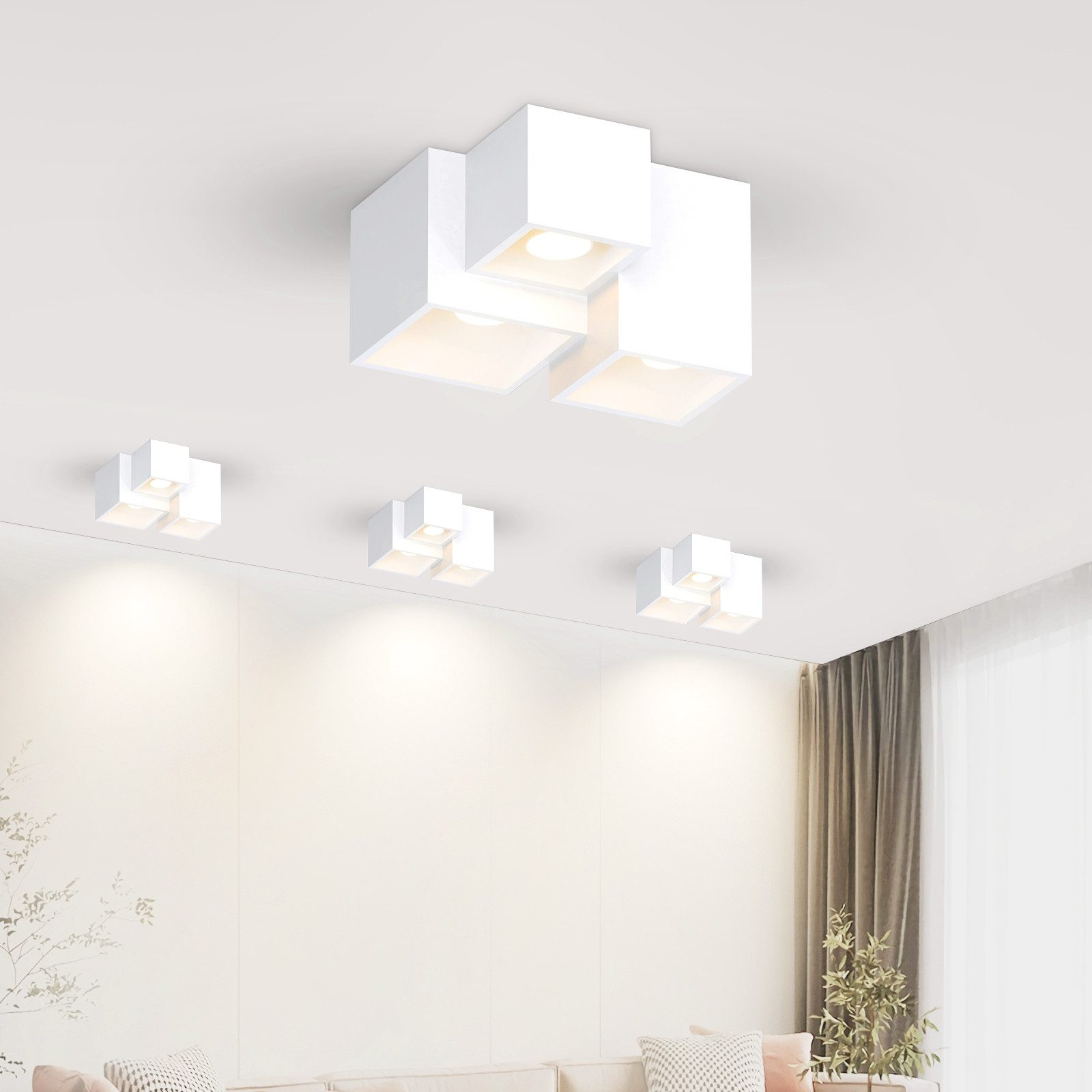 Múltiples luces cúbicas blancas, colgadas de un techo blanco.