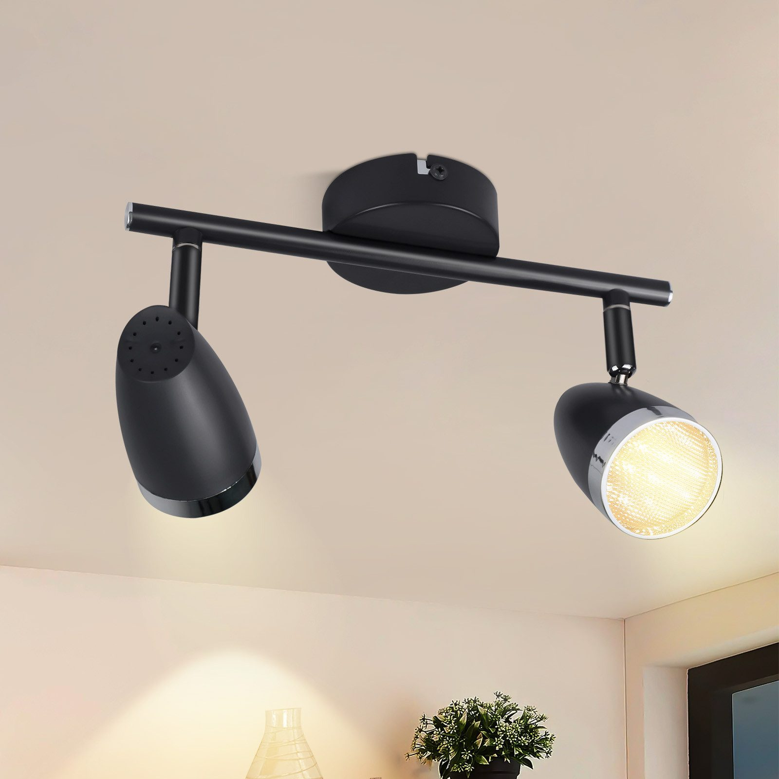 Faretto da soffitto nero con due lampade regolabili. Il soffitto è bianco.