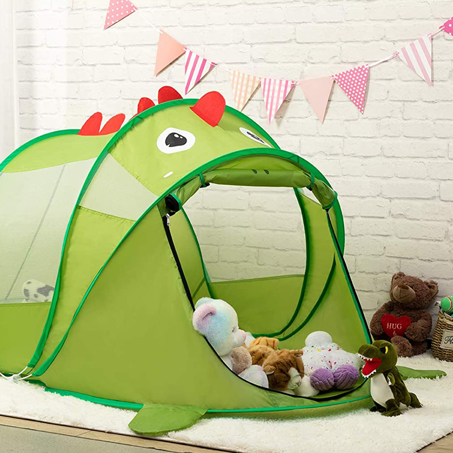 Tienda de dinosaurio verde con juguetes dentro, rodeada de pared de ladrillos blancos y banderas.