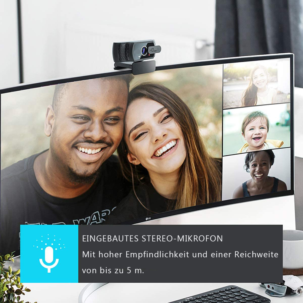 Eine Webcam auf einem Monitor. Zeigt einen Videoanruf mit lächelnden Personen. Text: Eingebautes Stereomikrofon.