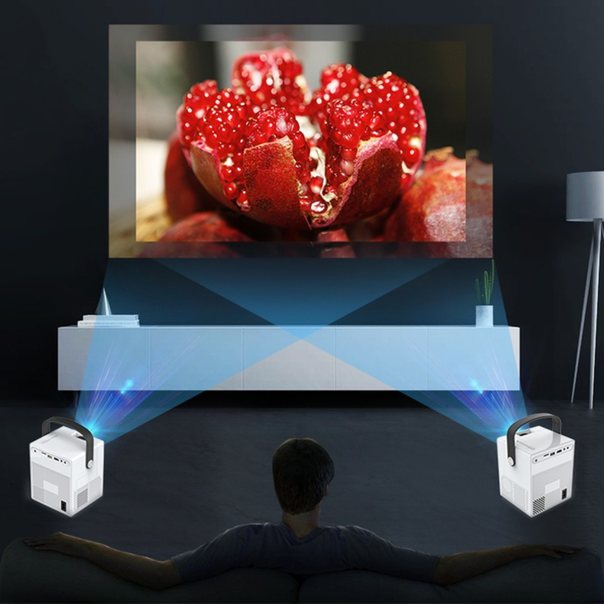 Mann schaut Film von zwei Projektoren auf Leinwand, rotes Granatapfel-Bild.