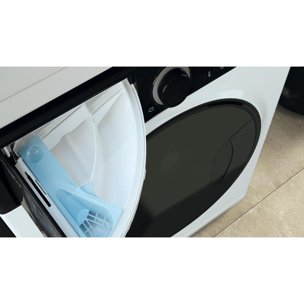 Zbliżenie otwartej szuflady na detergent białej pralki. Widoczny niebieski dozownik detergentu.