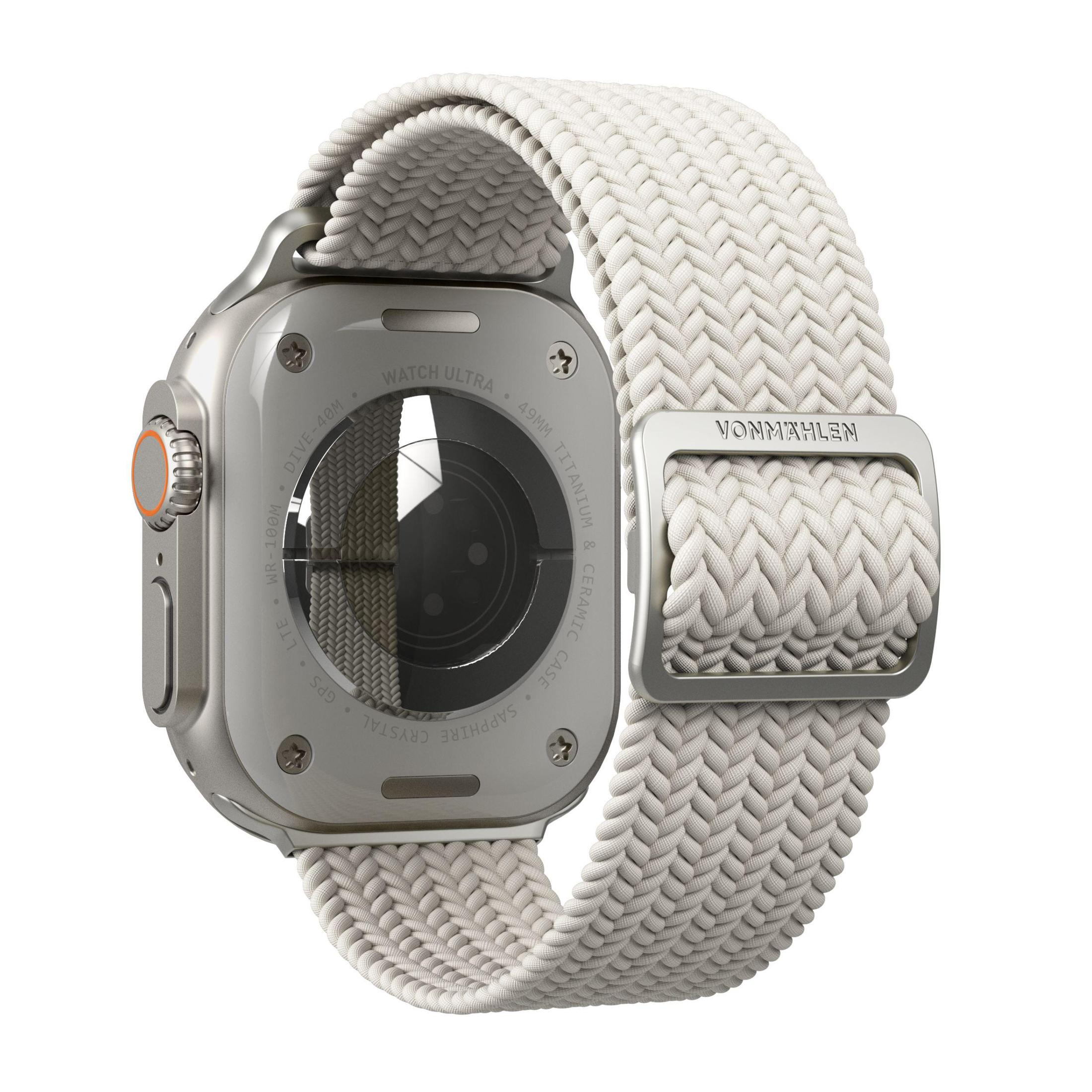 Un Apple Watch Ultra argento con un cinturino intrecciato bianco e una fibbia.
