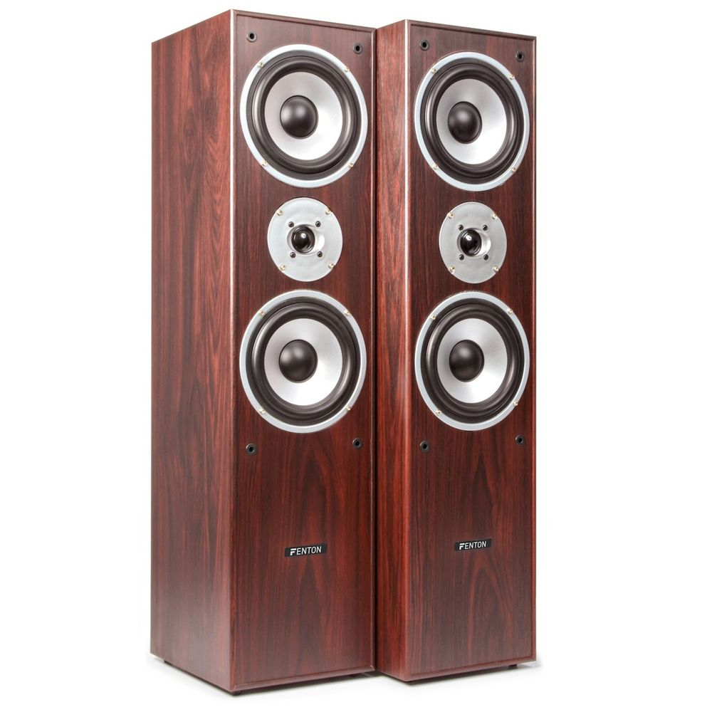 Dos altavoces altos y marrones con anillos plateados alrededor de los altavoces.