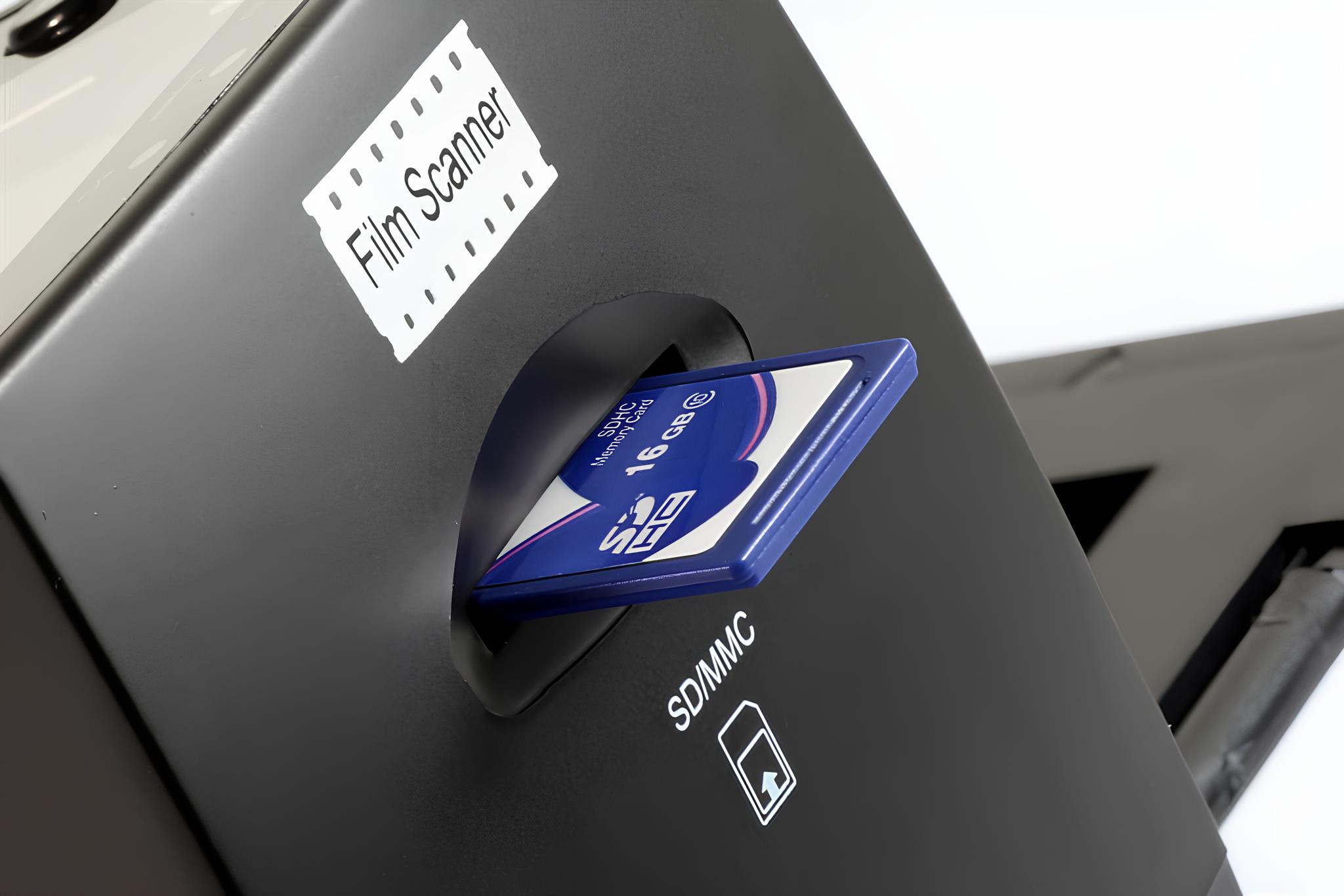 SD-Karte in schwarzen Filmscanner gesteckt. Ein Etikett sagt 'Film Scanner'.