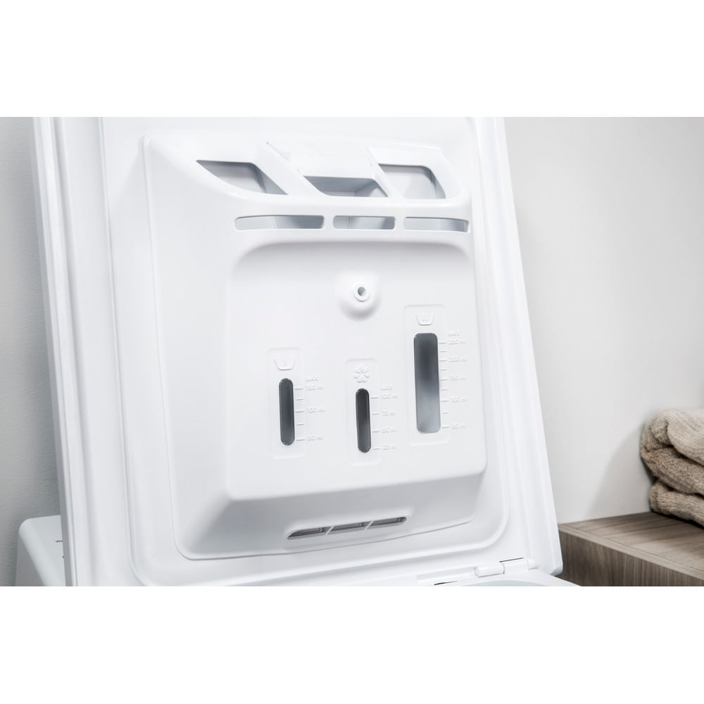 Zbliżenie szuflady na detergent pralki. Jest biała i ma przegródki.