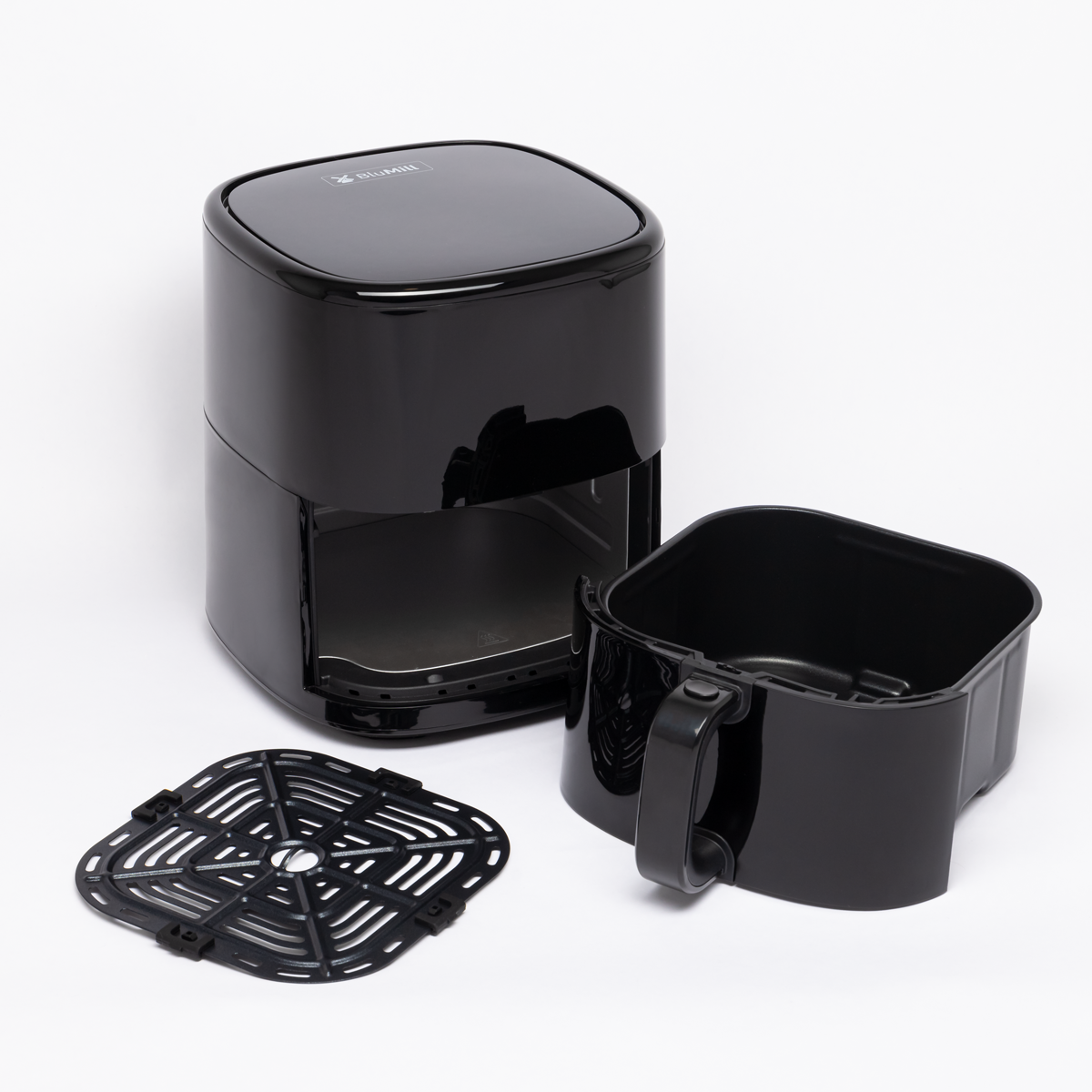 Zwarte airfryer met mand en rooster op een wit oppervlak. De onderdelen zijn los.