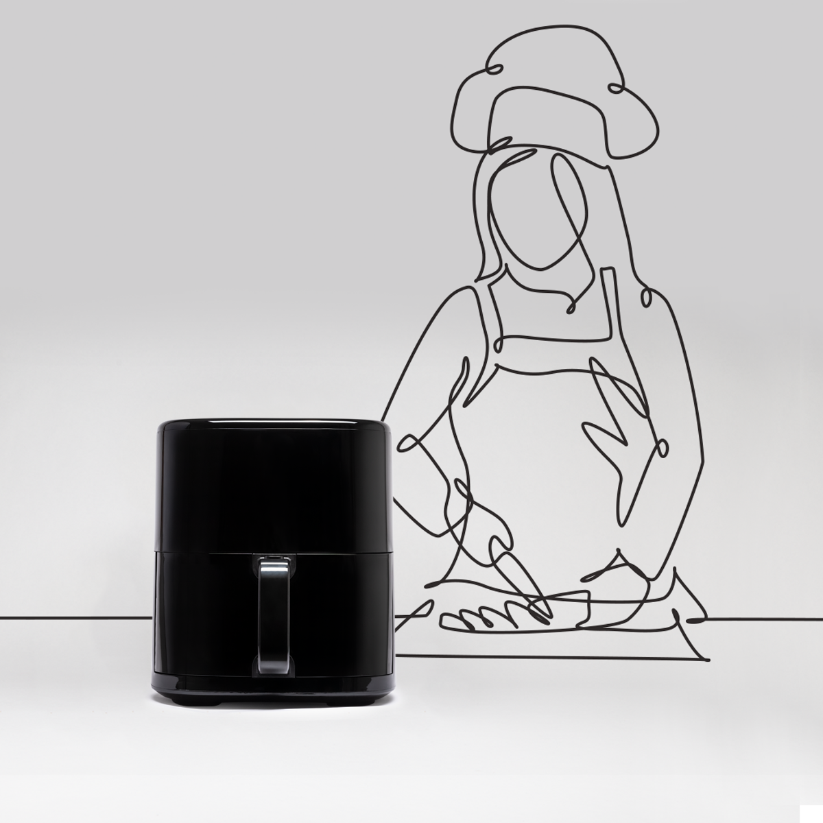 Zwarte airfryer met een omtrek van een chef-kok getekend op de achtergrond.