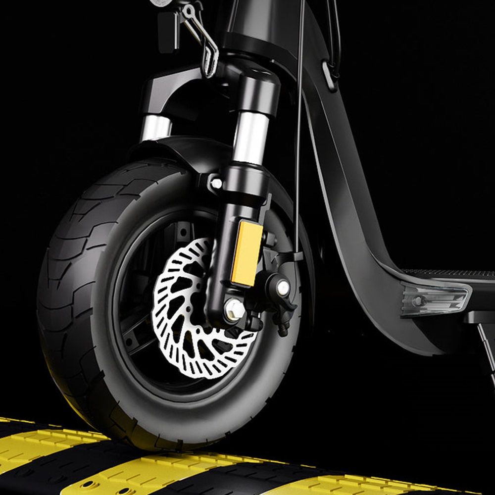 Nahaufnahme eines E-Scooter-Rads, schwarz und silber, auf einem Speed-Bump.
