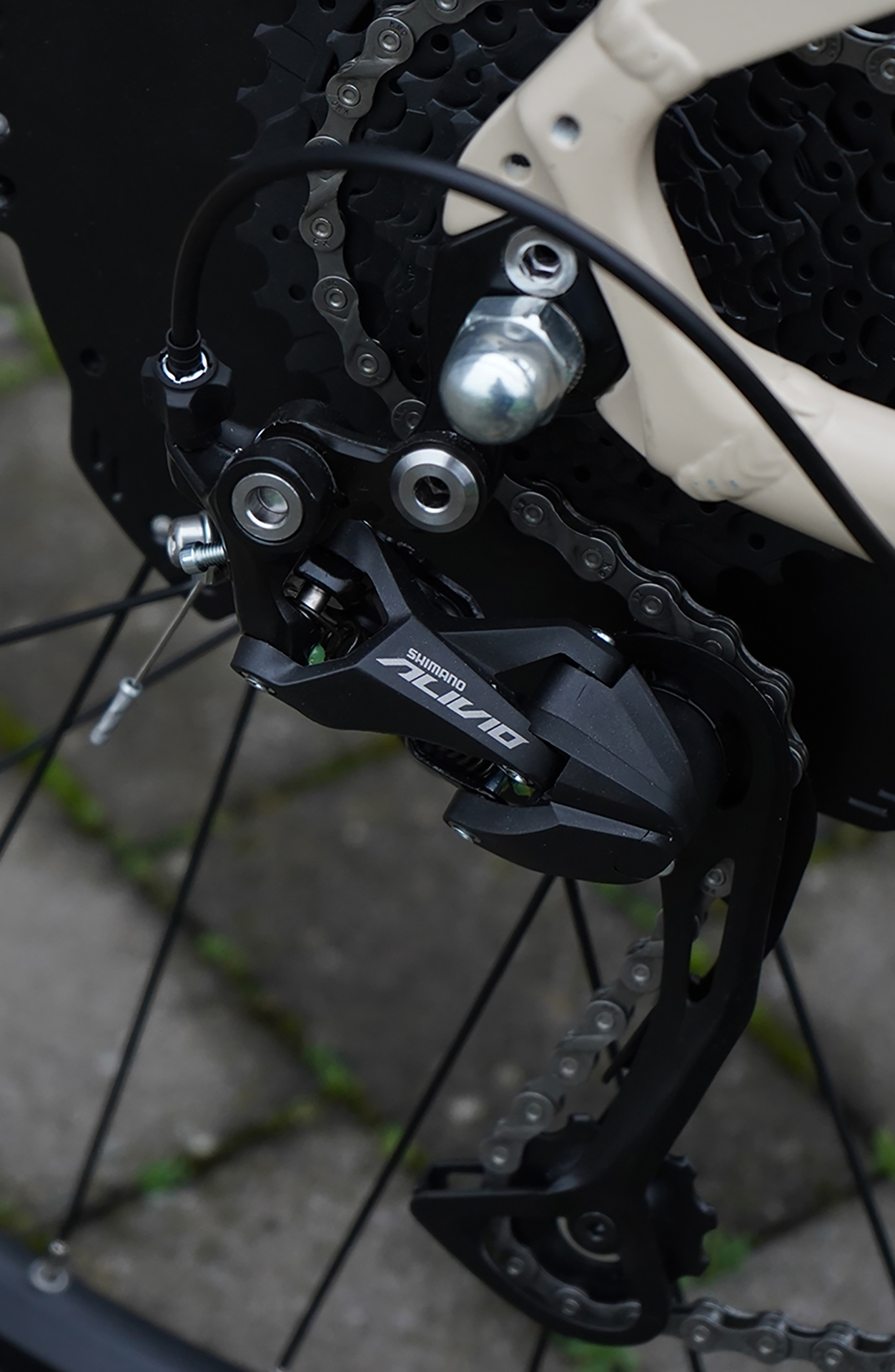 Ein Fahrrad-Schaltwerk mit dem Namen Shimano Alivio, Kette und Rad sichtbar.