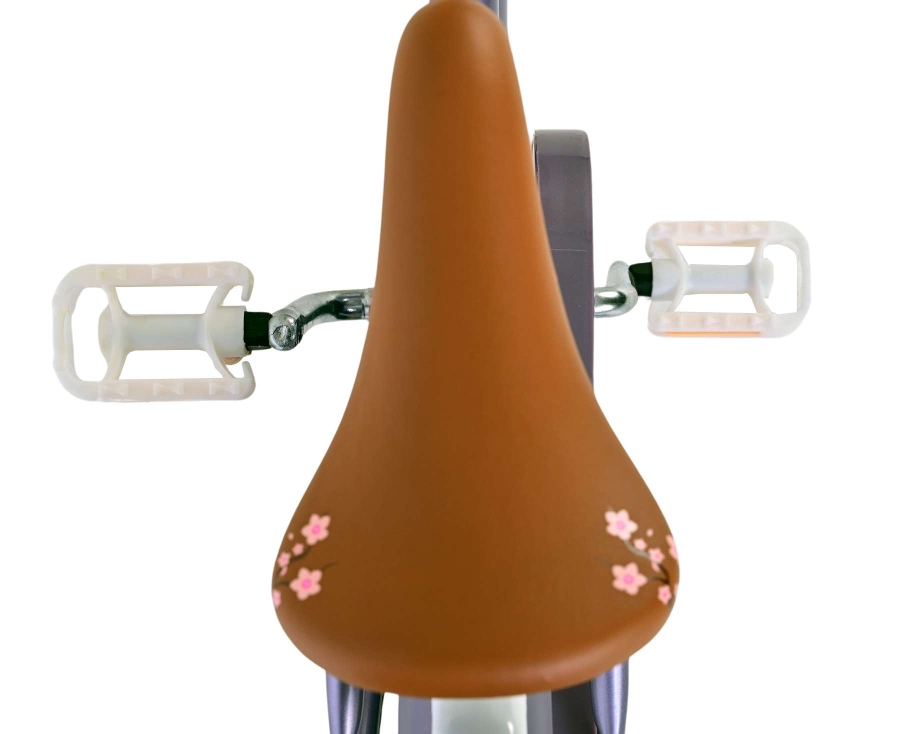 Ein brauner Fahrradsattel mit rosa Blumendesigns und weißen Pedalen.