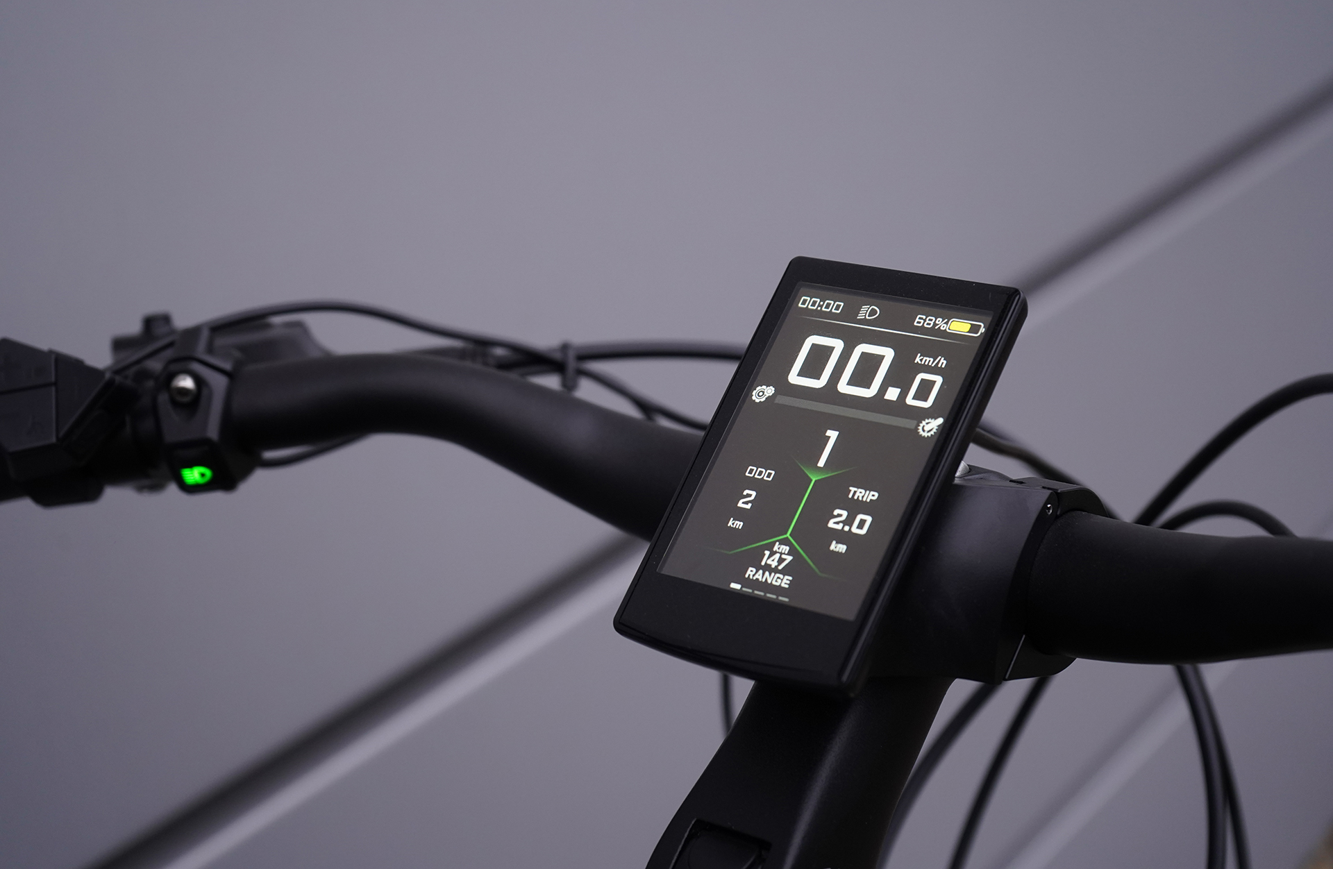 Nahaufnahme des Fahrradlenkers mit digitaler Anzeige von Geschwindigkeit und anderen Metriken.