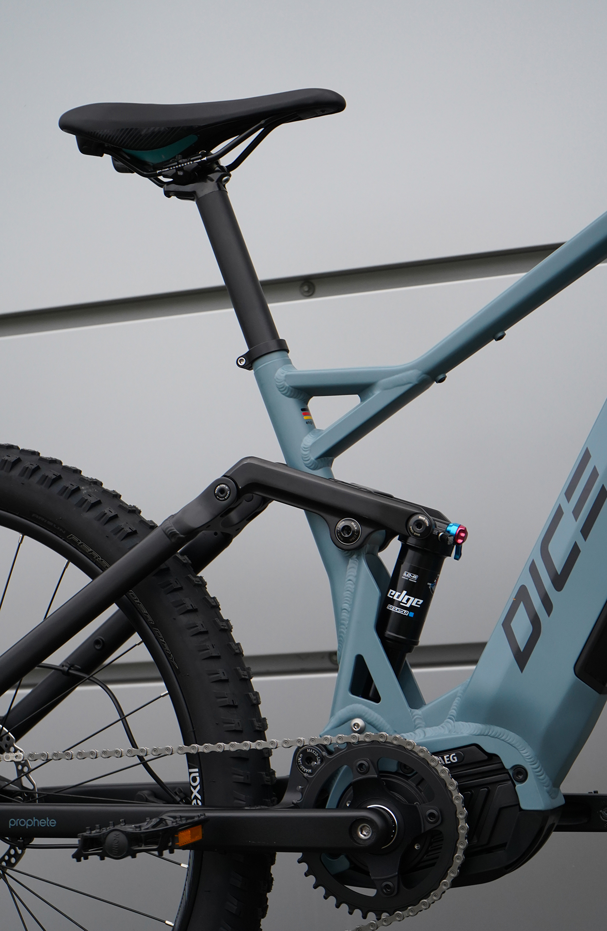 Nahaufnahme des Rahmens, Sitzes und der hinteren Federung eines Mountainbikes. Grau- und Schwarztöne.