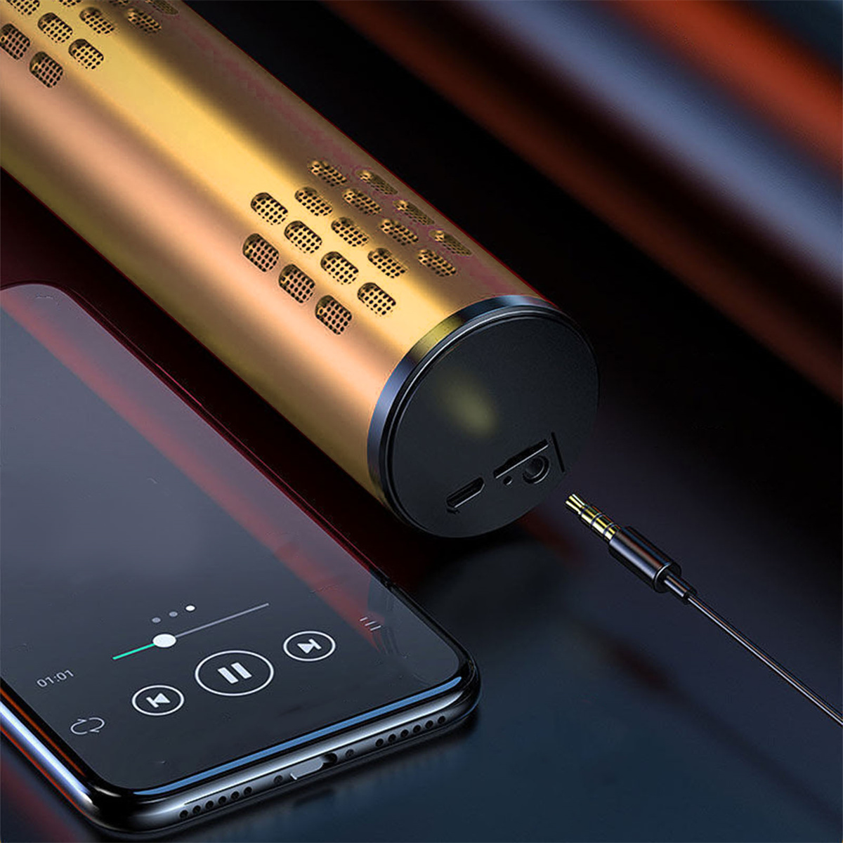 Ein goldener Lautsprecher ist über eine Kopfhörerbuchse mit einem schwarzen Telefon verbunden. Das Telefon zeigt Musiksteuerungen.