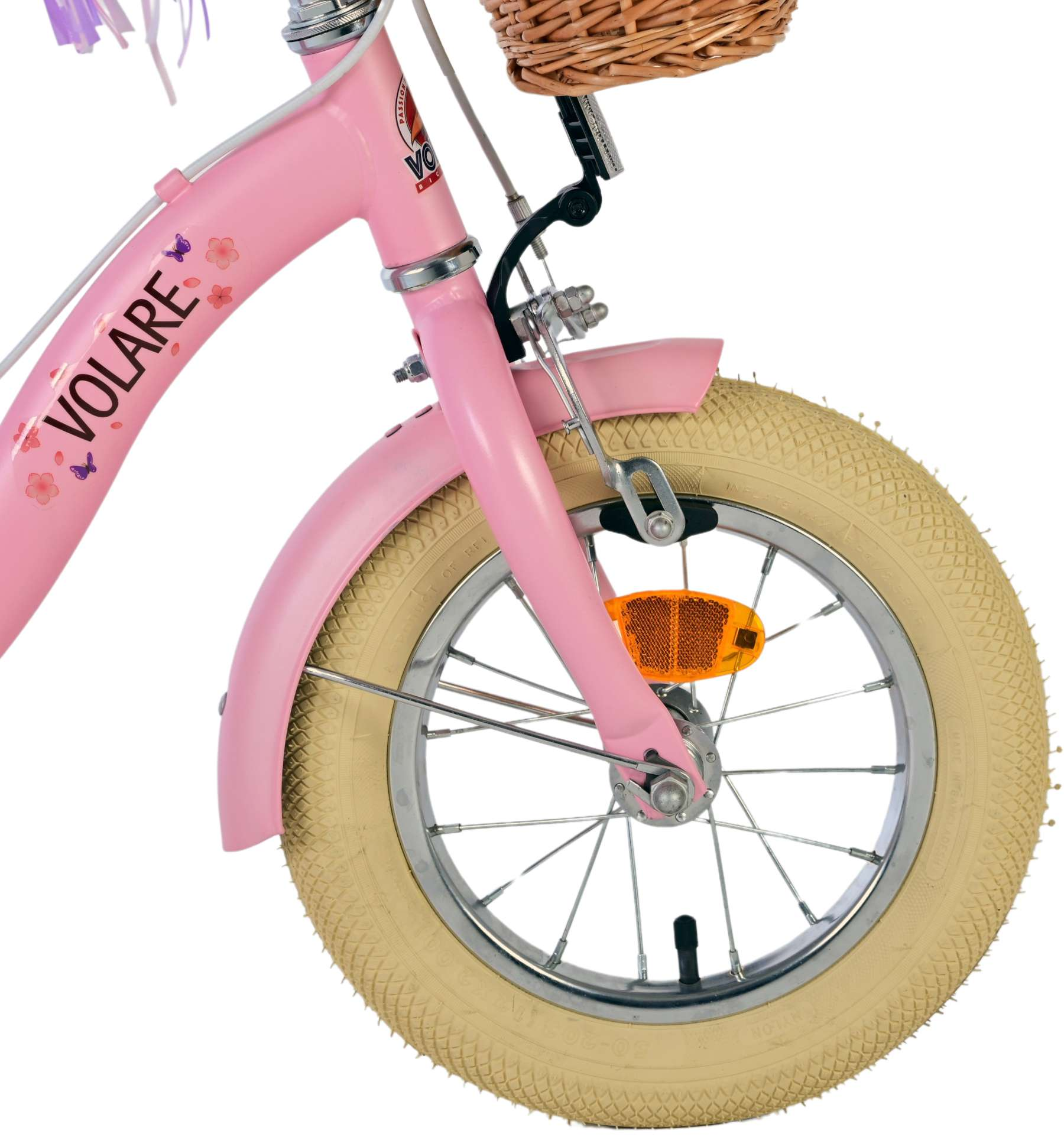 Nahaufnahme der Front eines rosa Fahrrads. Es hat einen Korb, eine Blume und einen beigen Reifen.