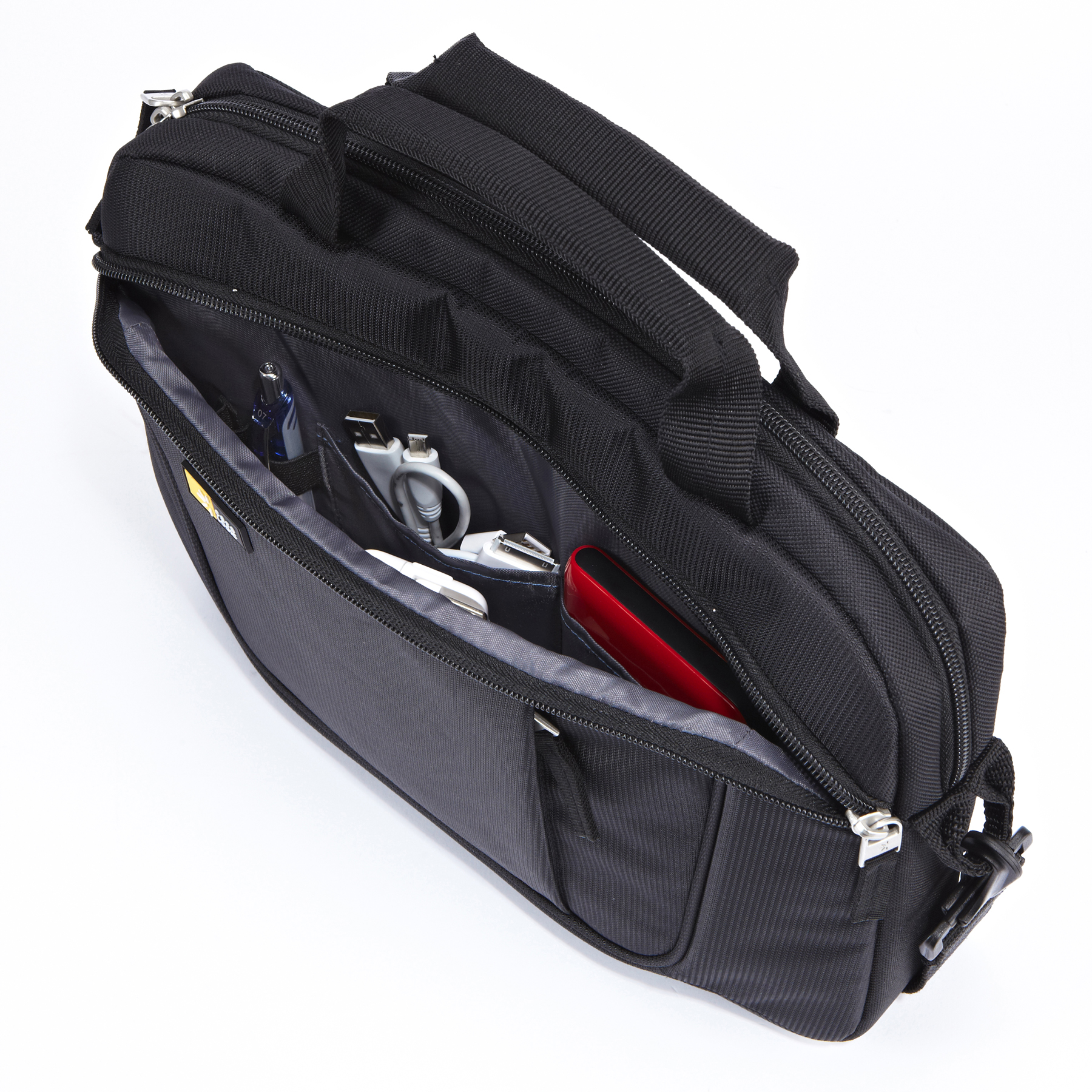 Zwarte open tas met inhoud: kabels, pennen en een rood apparaat.
