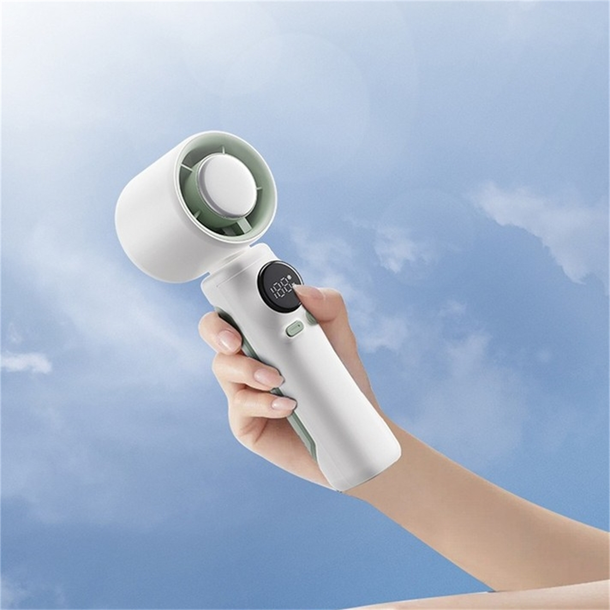 Die Hand einer Person, die einen weißen und grünen tragbaren Ventilator mit digitaler Anzeige hält.