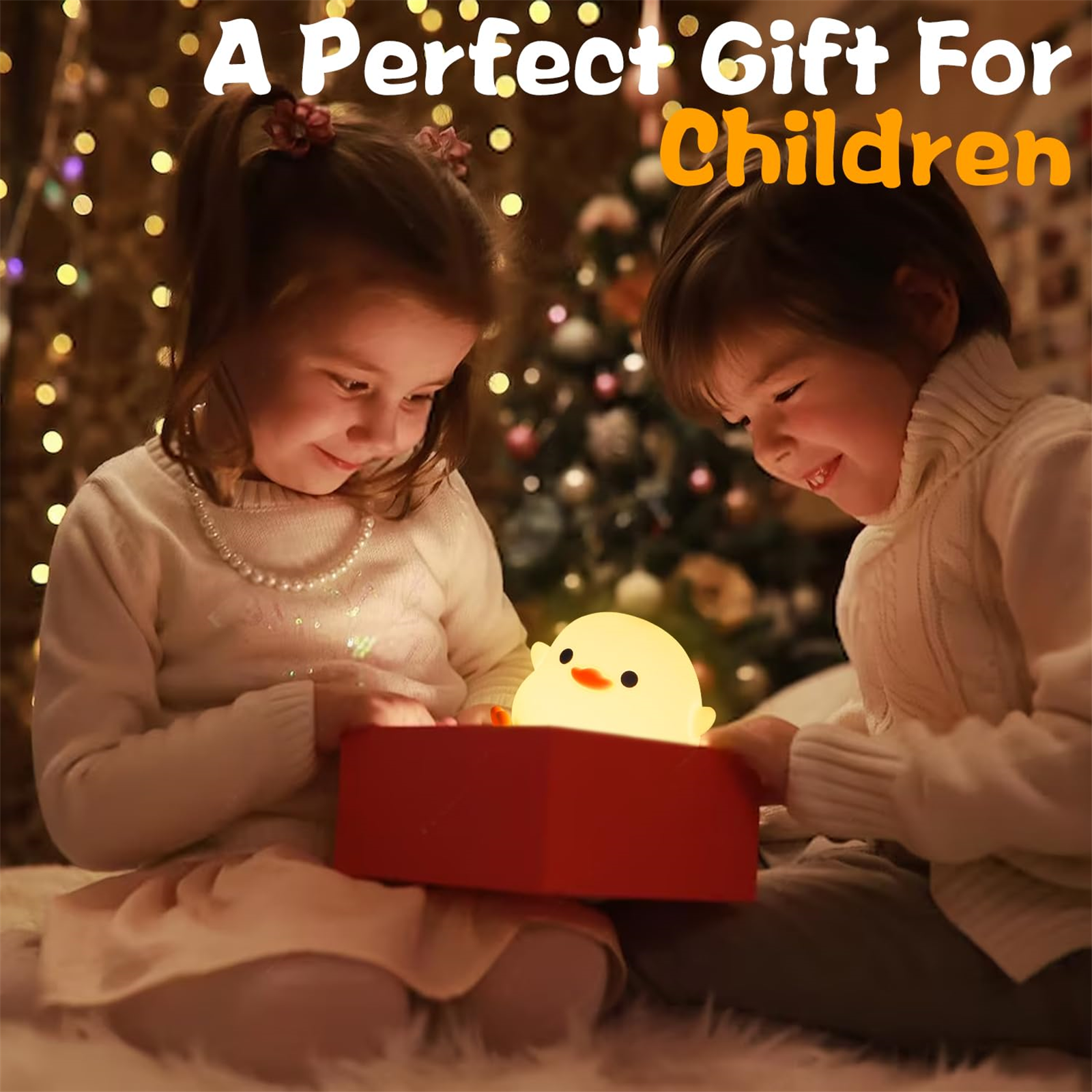 Zwei Kinder schauen sich eine leuchtende Kükenlampe in einer Geschenkbox an. Text: Ein perfektes Geschenk für Kinder.