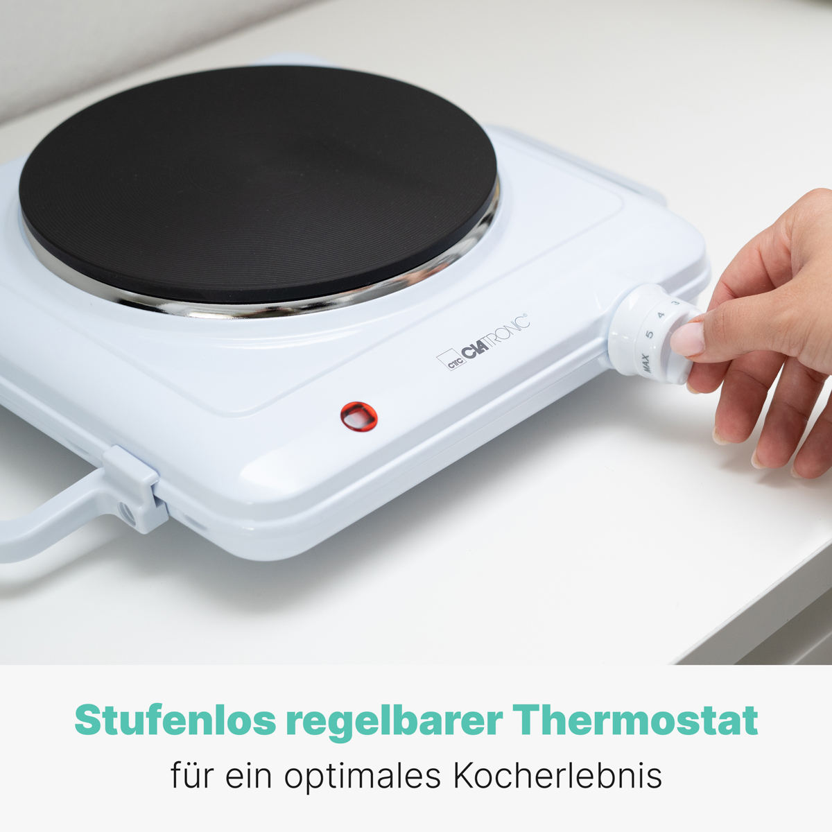 Biała płyta grzewcza. Ręka obraca pokrętło temperatury. Tekst: Termostat.