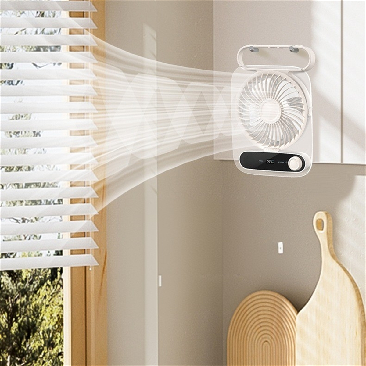 Ein weißer tragbarer Ventilator, der Luft nach rechts bläst, an einer hellbraunen Wand, in der Nähe von Jalousien und Holz.