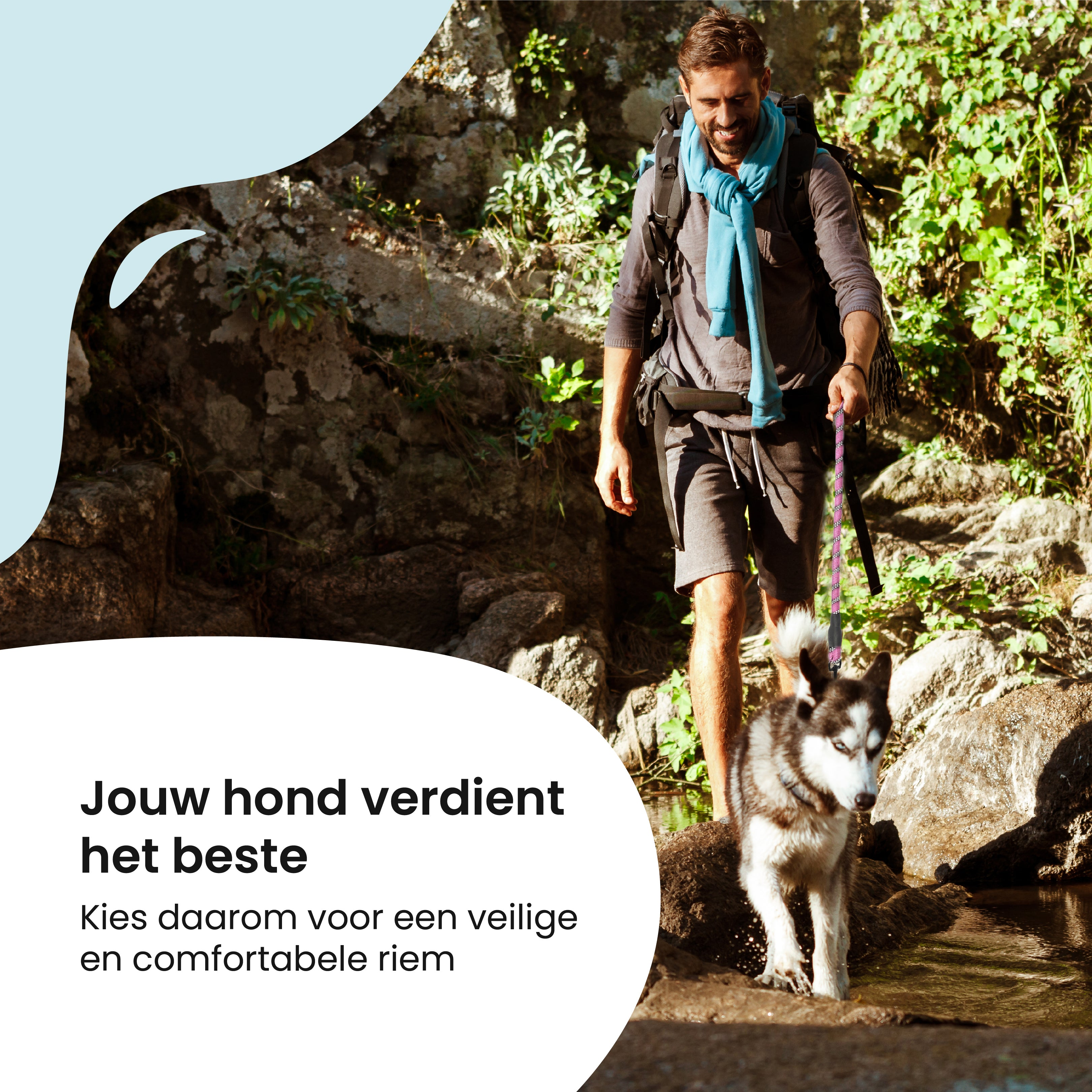 Man hiking with dog on leash.  They are walking near a stream on a rocky path.