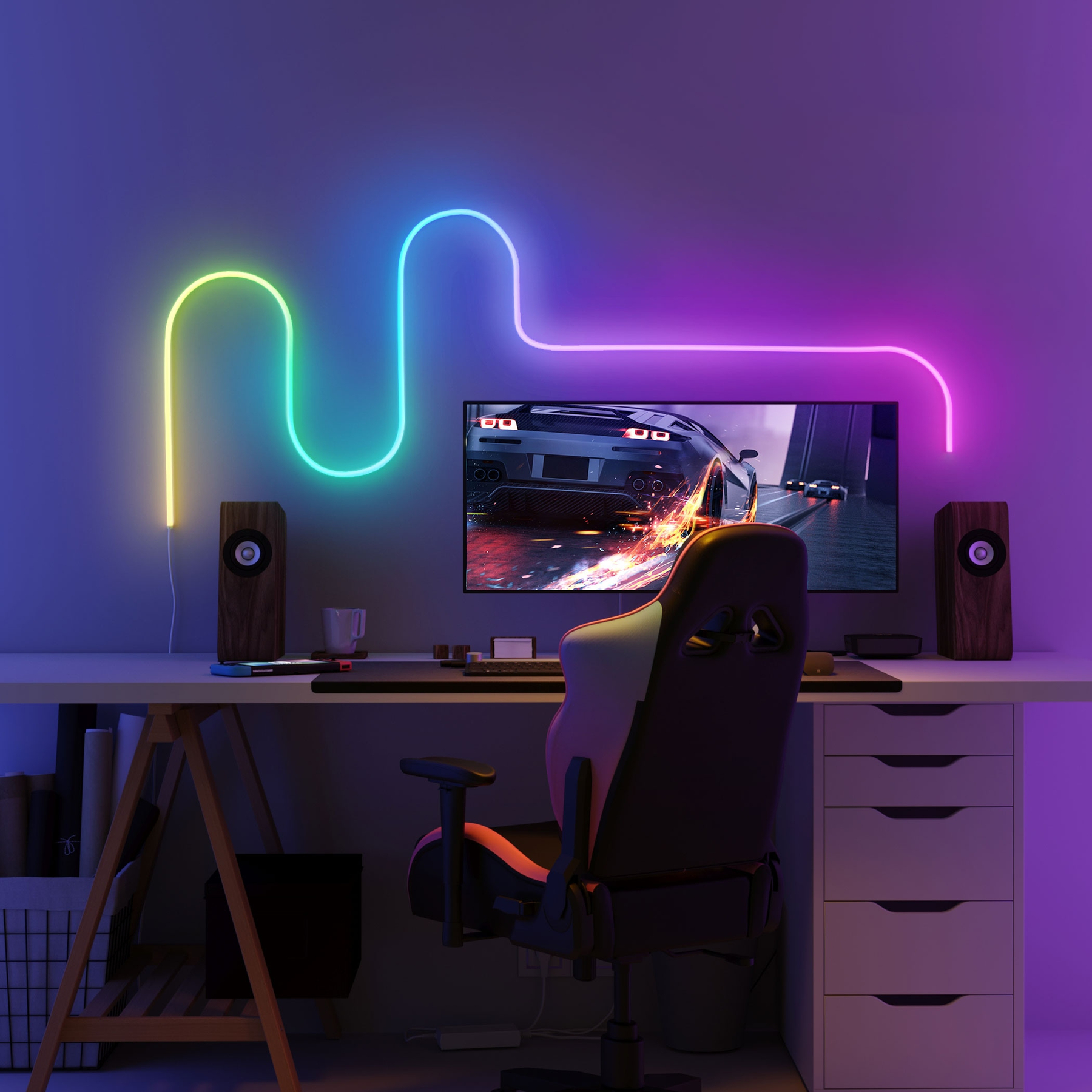 Configurazione di gioco con monitor, altoparlanti e luce al neon, in una stanza illuminata di viola.
