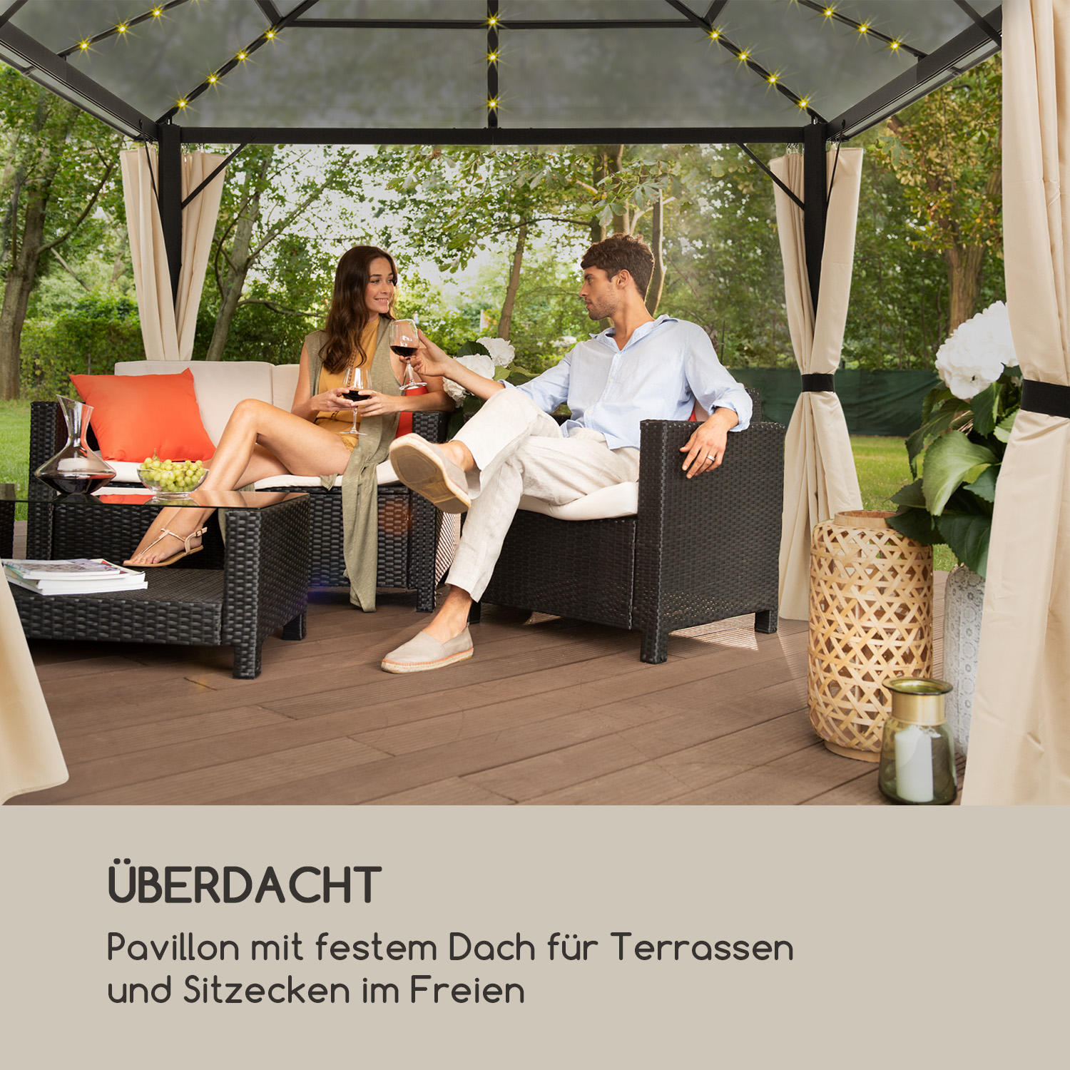 Paar sitzt in einem Pavillon. Sie stoßen mit Wein an. Der Hintergrund ist ein grüner Rasen.