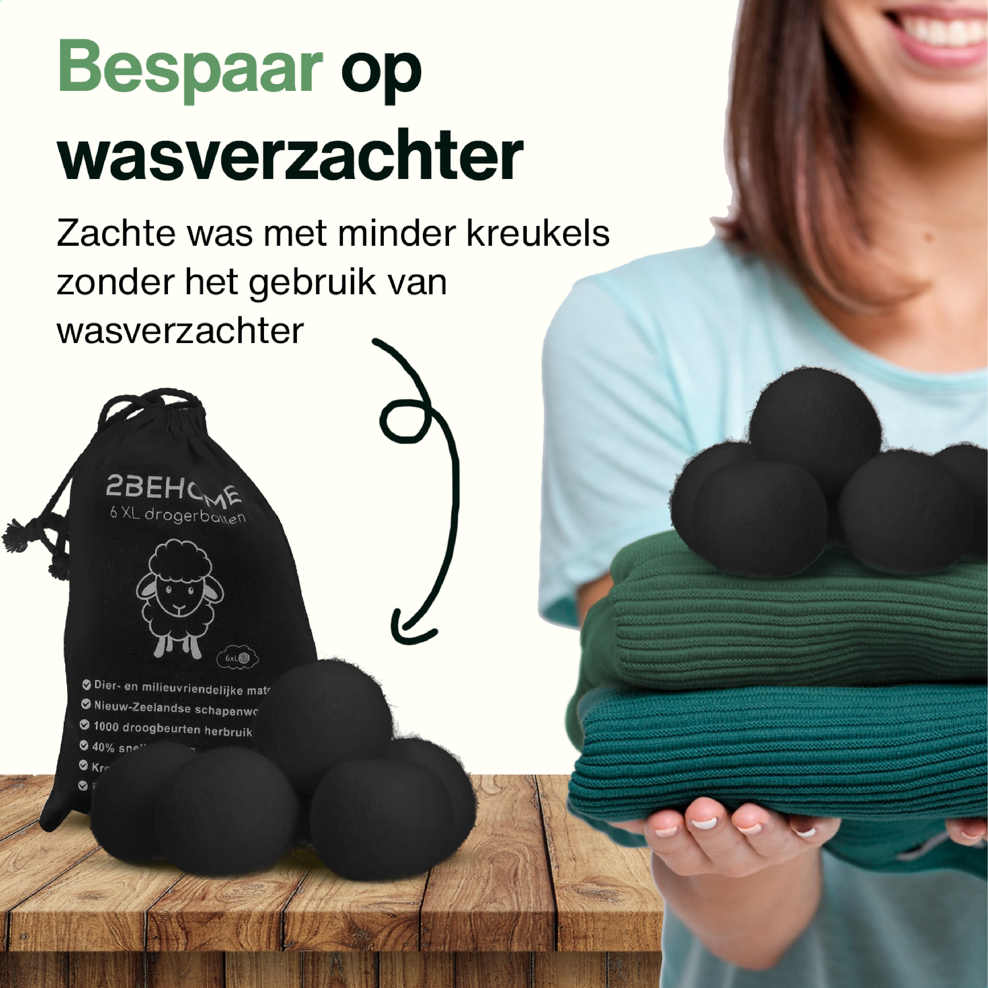 A woman shows black dryer balls and a stack of folded clothes.
