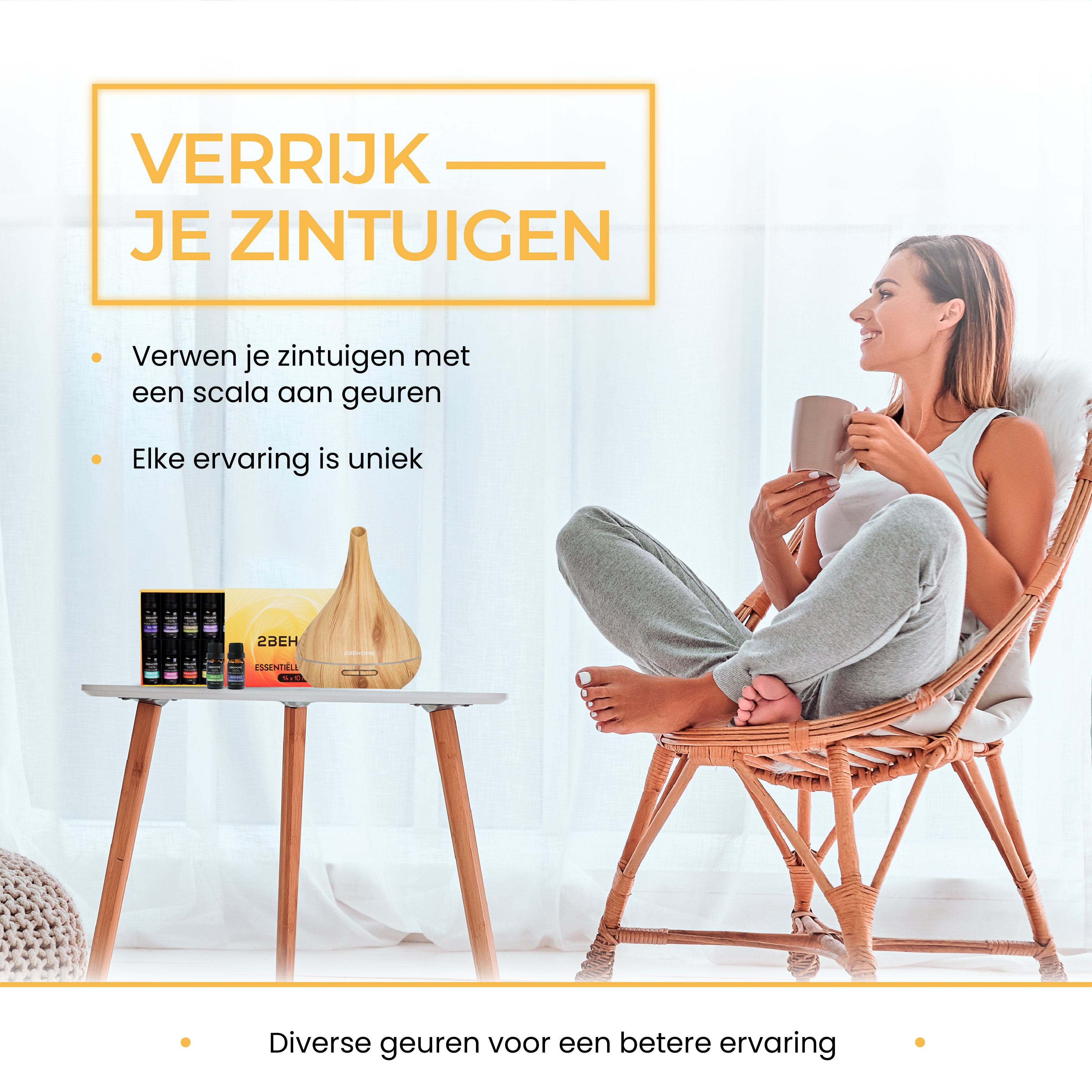 A woman is sitting and holding a cup next to an essential oil diffuser.