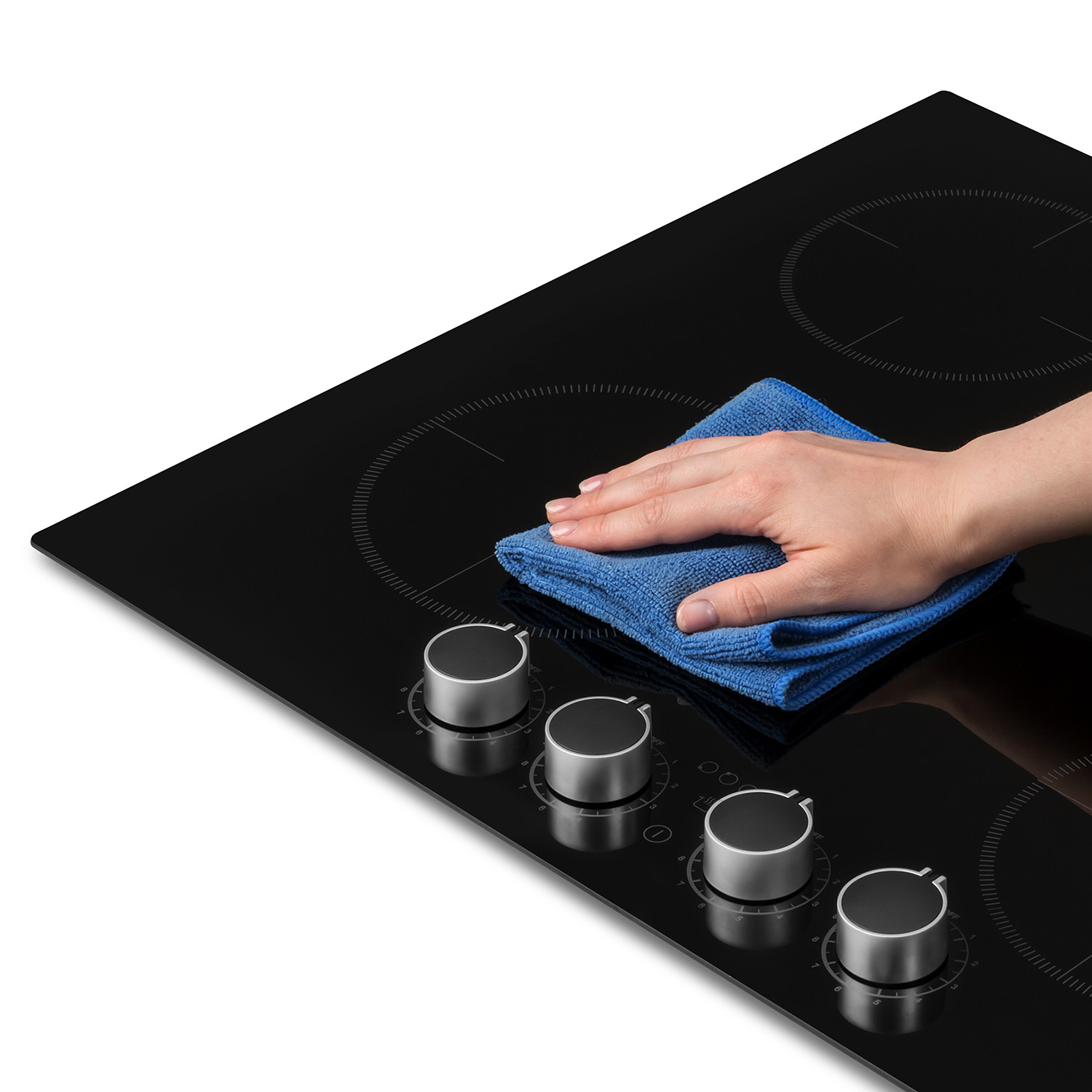 Una mano limpiando una placa de cocina negra con un paño azul.