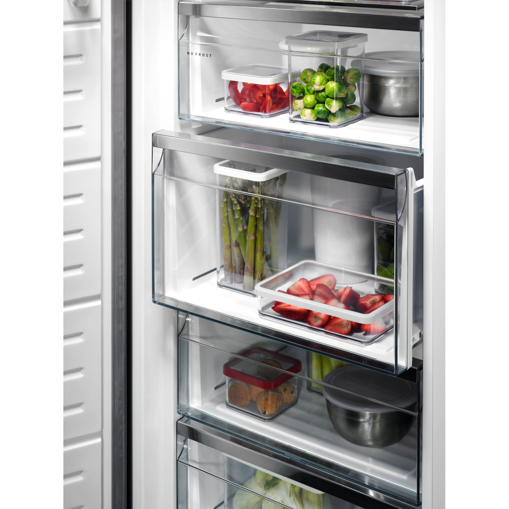 Refrigerador abierto, mostrando recipientes transparentes llenos de alimentos, incluyendo verduras y frutas.