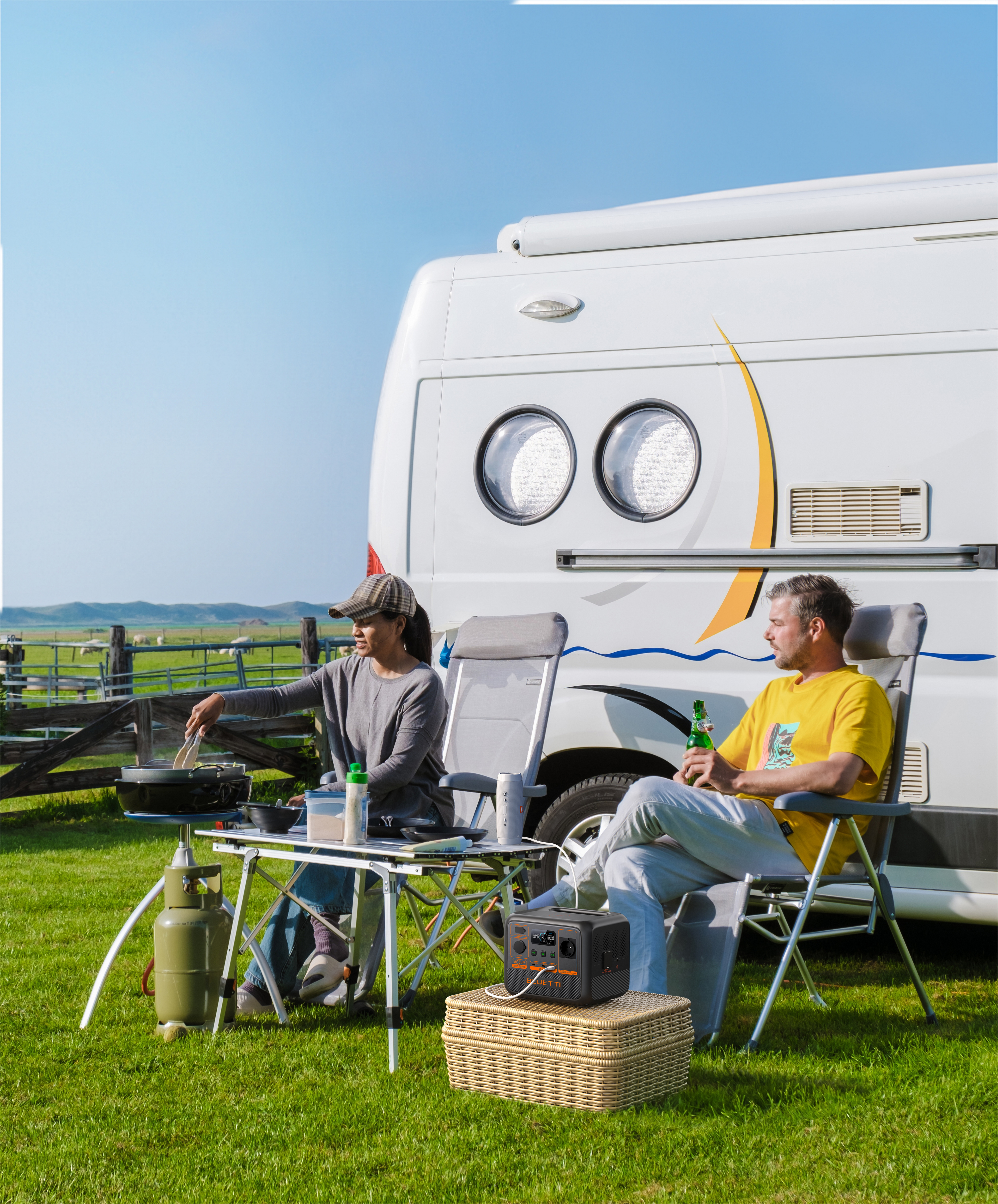 Ludzie biwakują z vanem, gotują jedzenie i siedzą na zewnątrz.