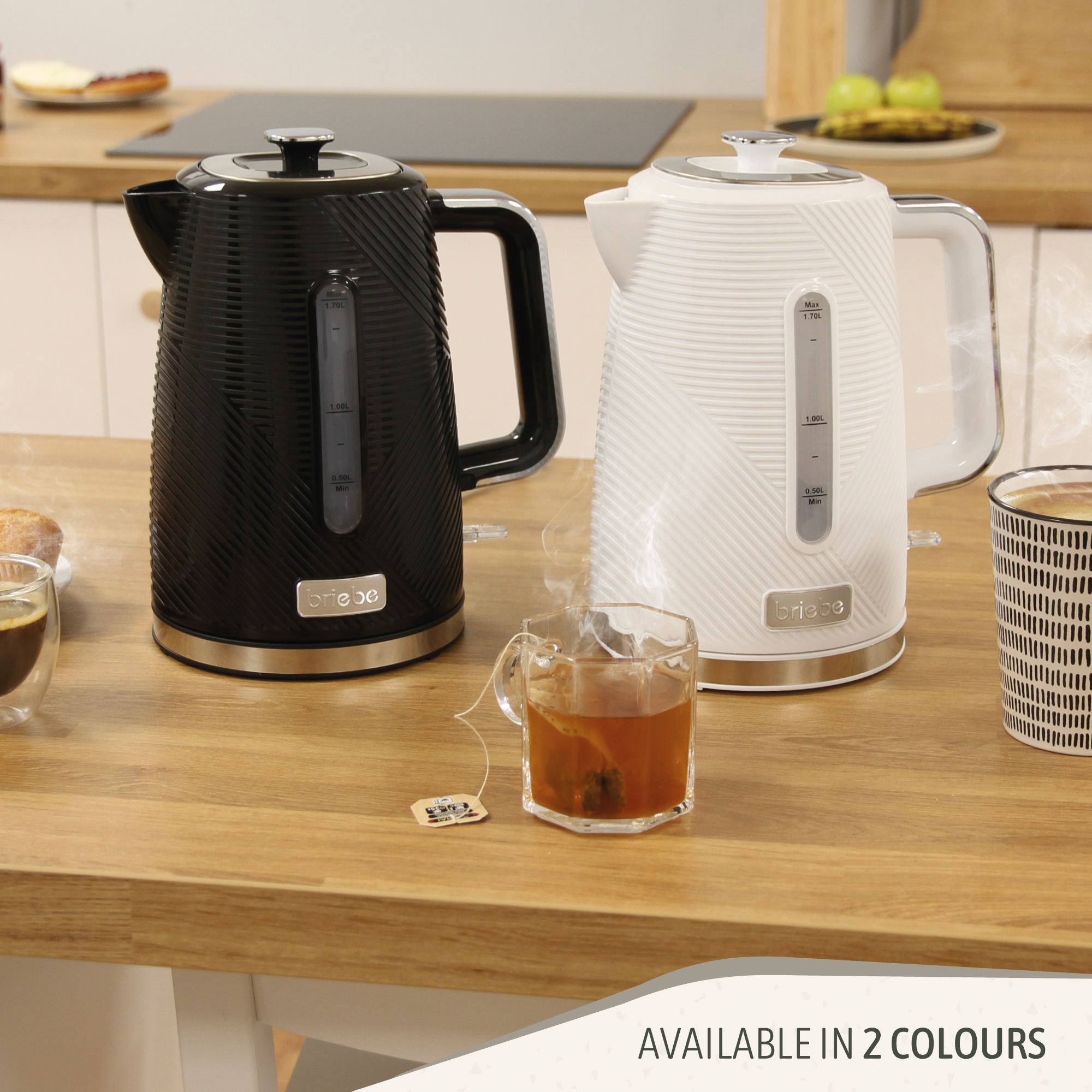 Dos teteras, negra y blanca, sobre una superficie de madera con té y una taza.