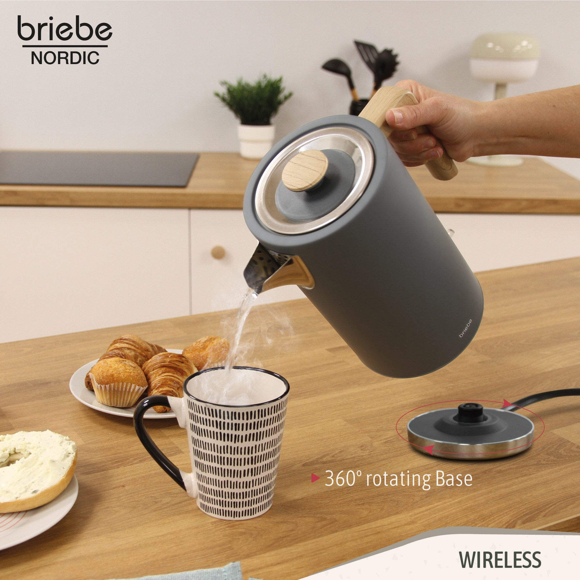 Una persona vertiendo agua de una tetera gris en una taza sobre una mesa de madera.