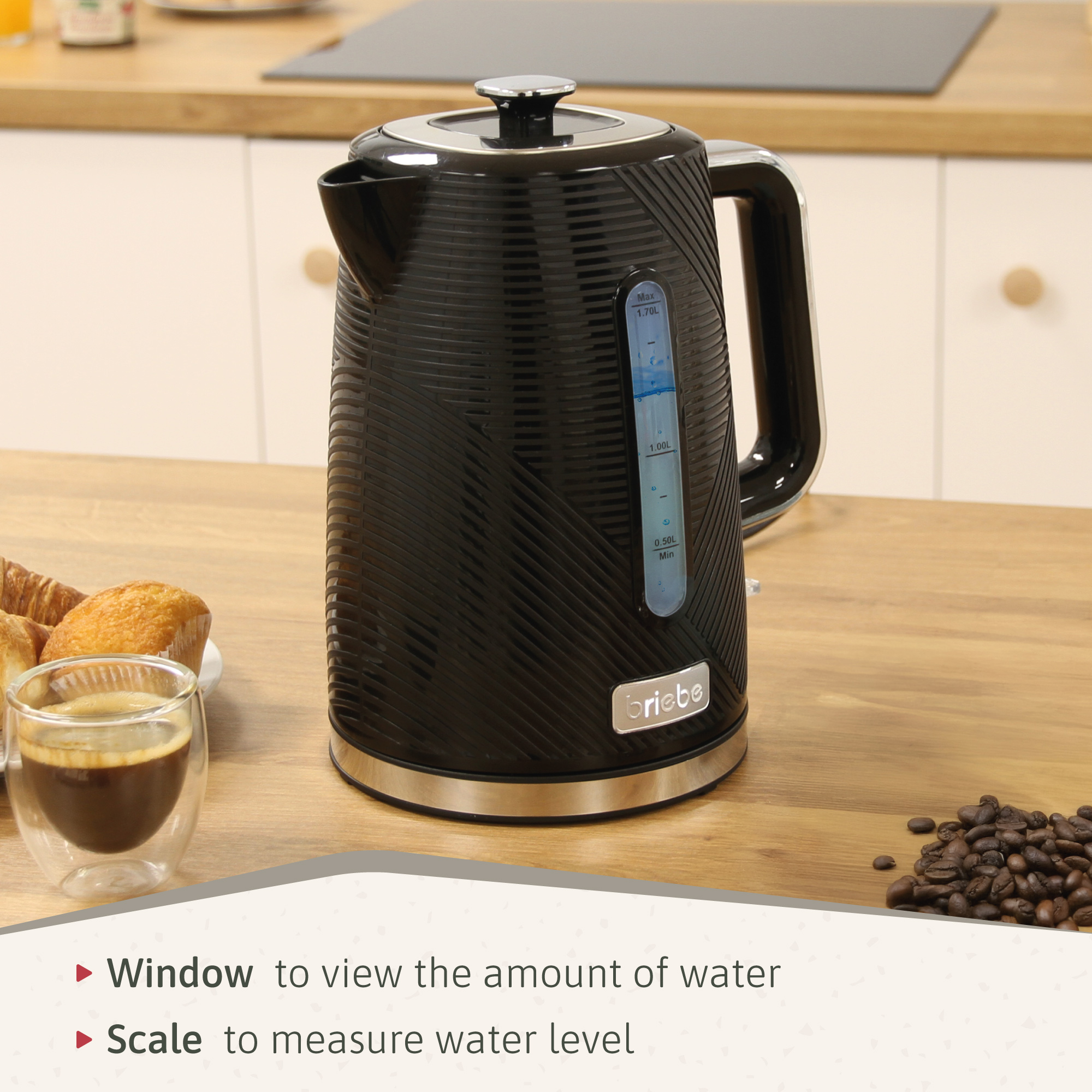 Hervidor eléctrico negro con asa y medidor de nivel de agua, sobre mesa de madera.
