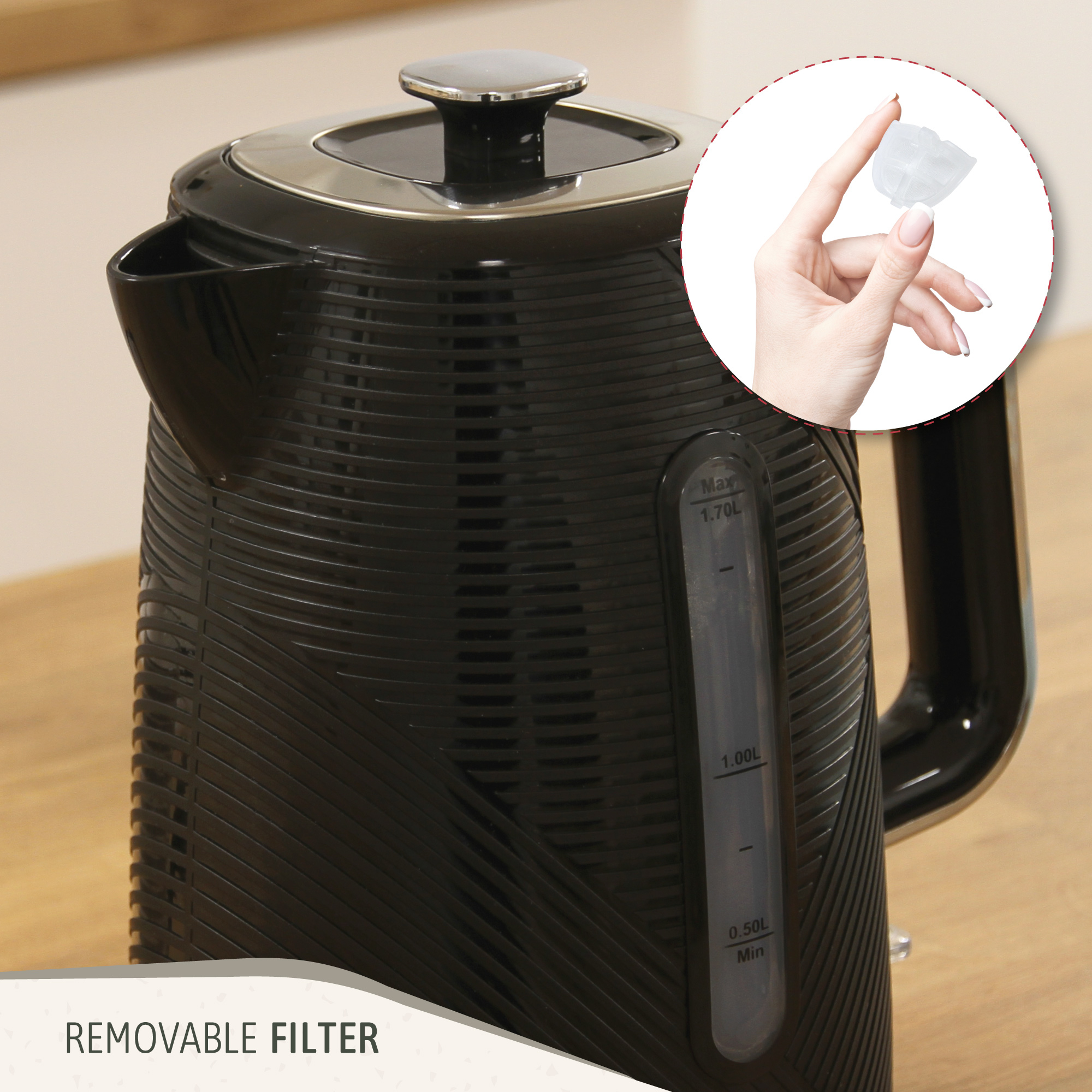 Una tetera negra con filtro extraíble. Una mano sostiene el filtro.