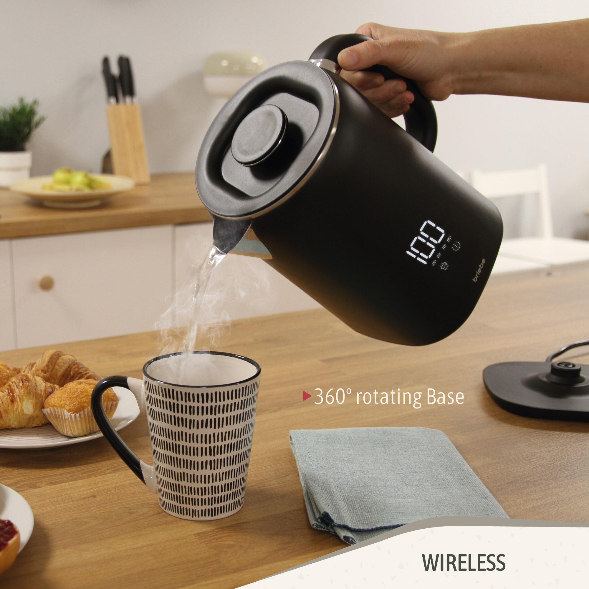 Ein schwarzer Wasserkocher gießt Wasser in eine Tasse, mit einer 100-Grad-Anzeige an der Seite.